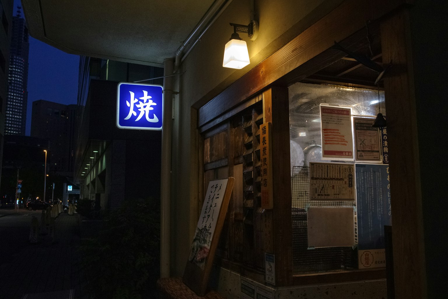 夜間的燒烤餐廳外觀 溫暖的燈光和木製入口