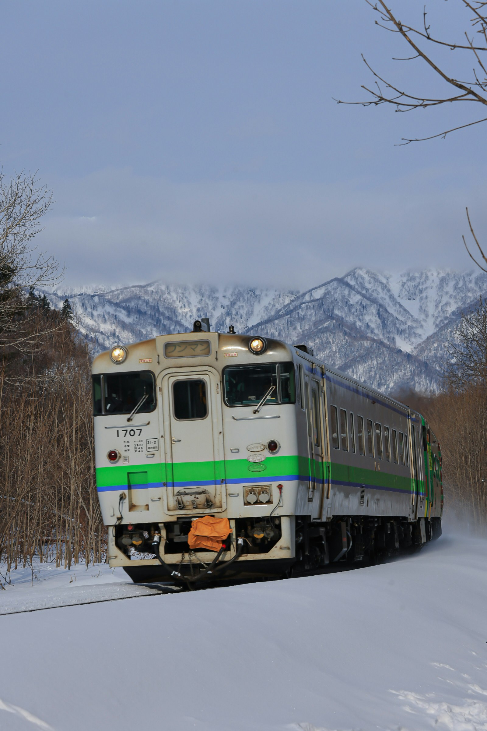 รถไฟแล่นผ่านภูมิประเทศที่ปกคลุมด้วยหิมะและสันเขาเขา