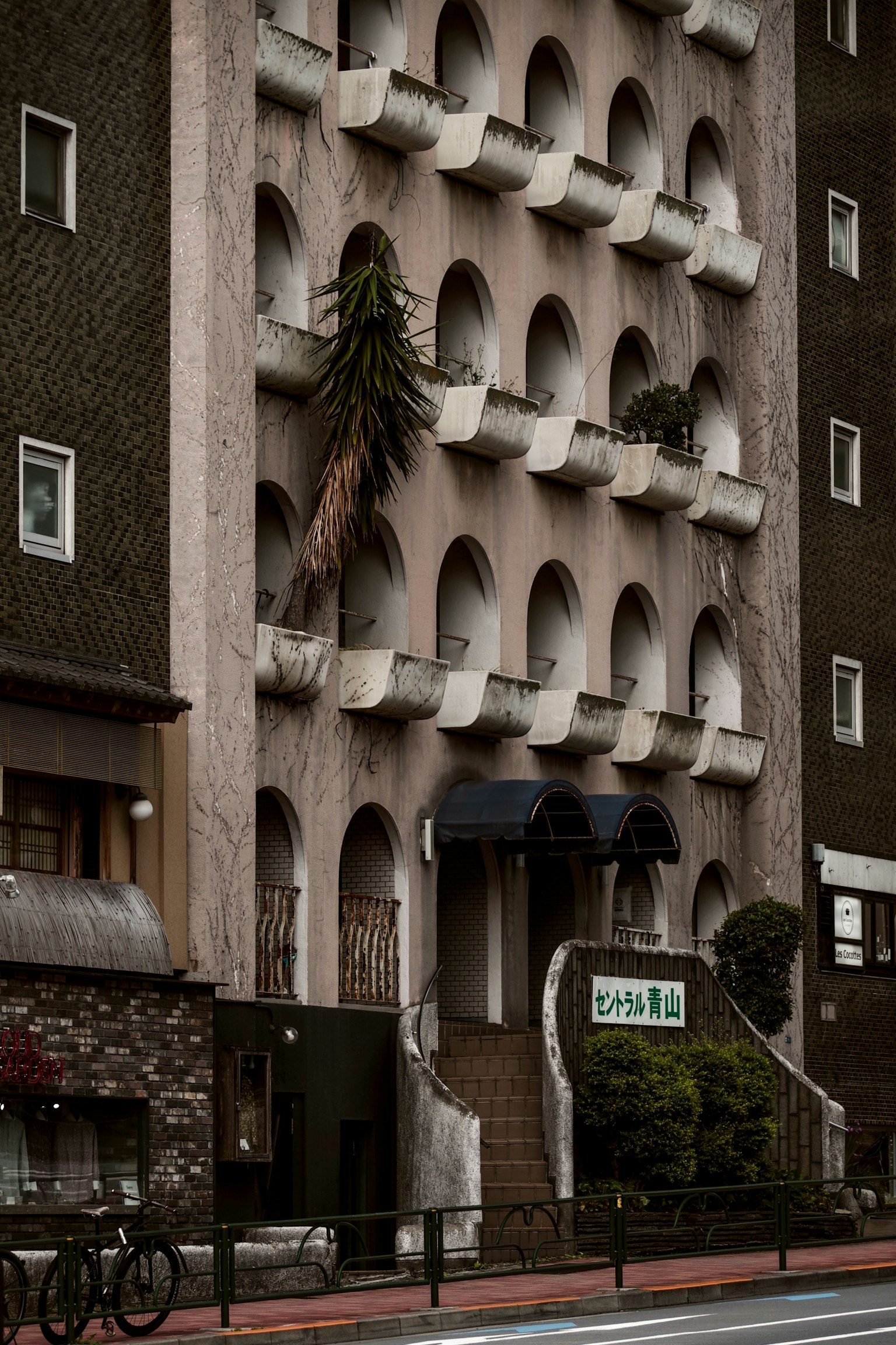 Exterior of a building with unique arched windows and a plant-adorned entrance