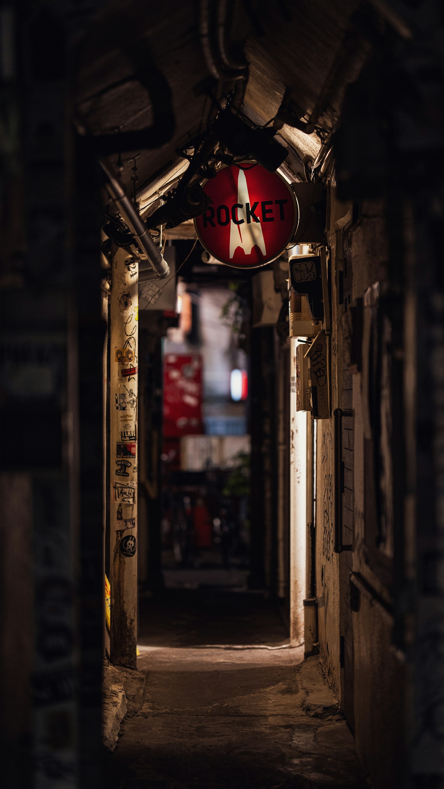 昏暗通道中懸掛著紅色標誌的狹窄小巷