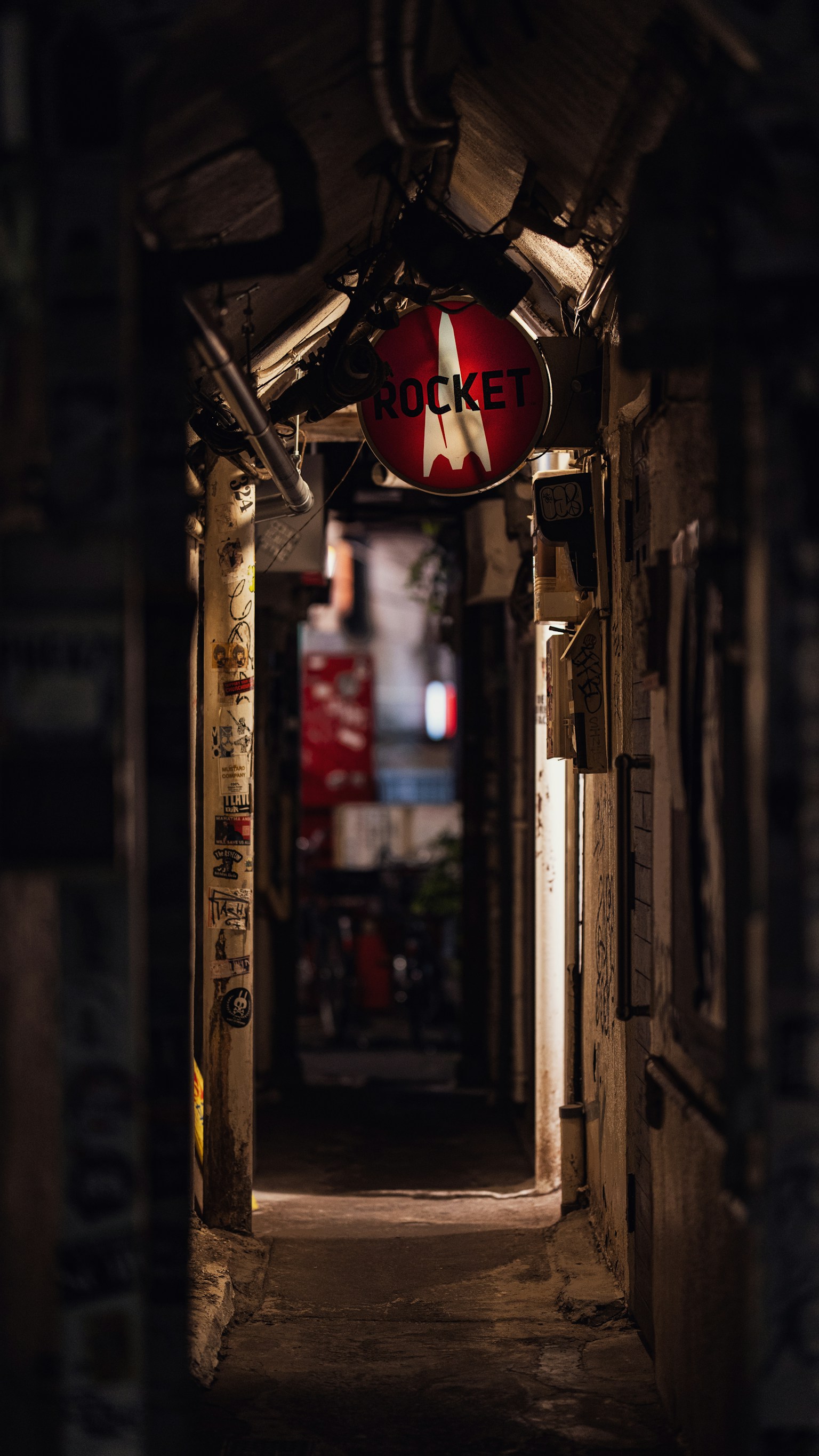 Enge Gasse mit einem roten Schild in einem schwach beleuchteten Durchgang