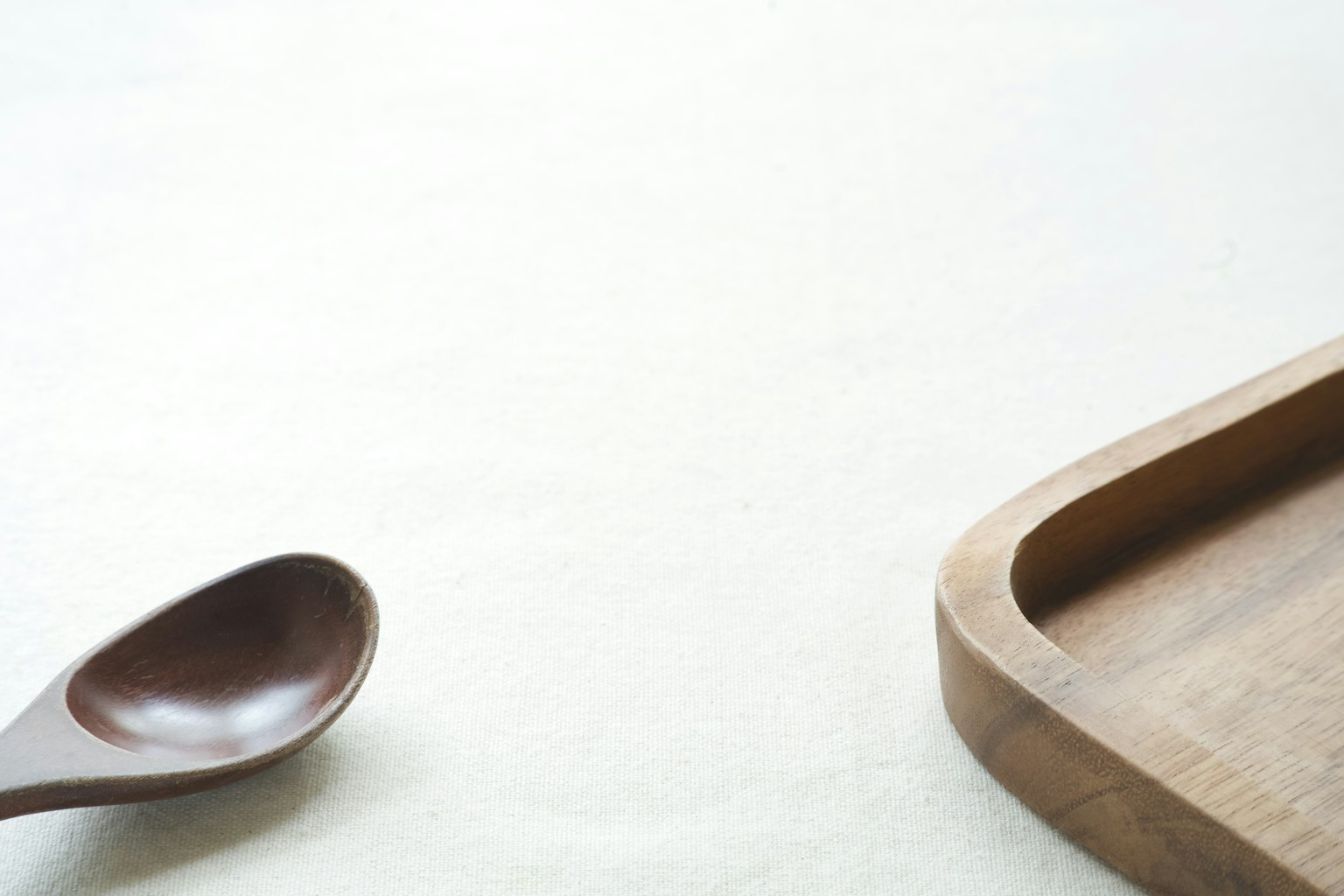 Una scena semplice di un tavolo con un cucchiaio di legno e un vassoio