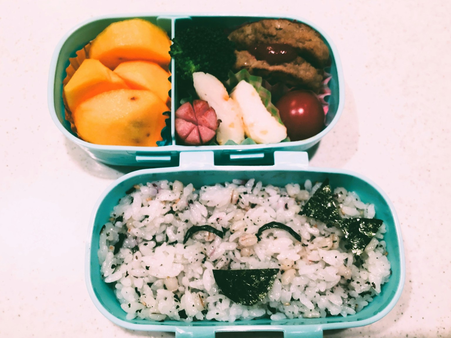青い弁当箱の中にご飯とおかずが詰まっている弁当の写真