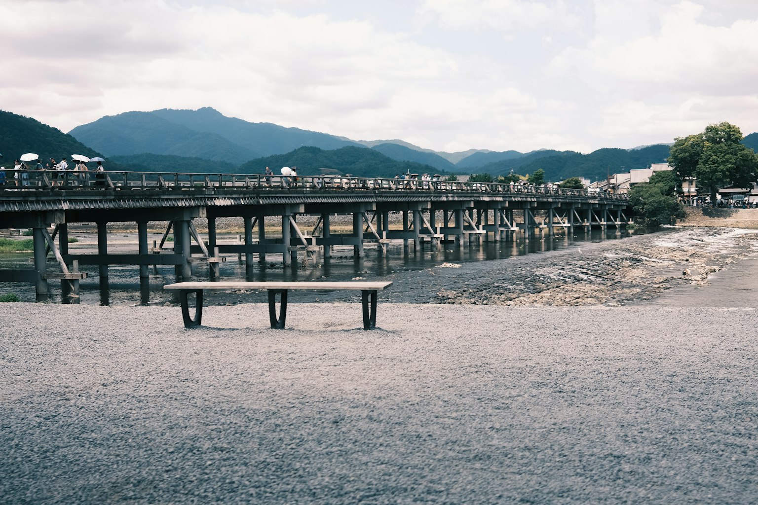 ทิวทัศน์ของสะพานไม้ใกล้แม่น้ำพร้อมม้านั่ง