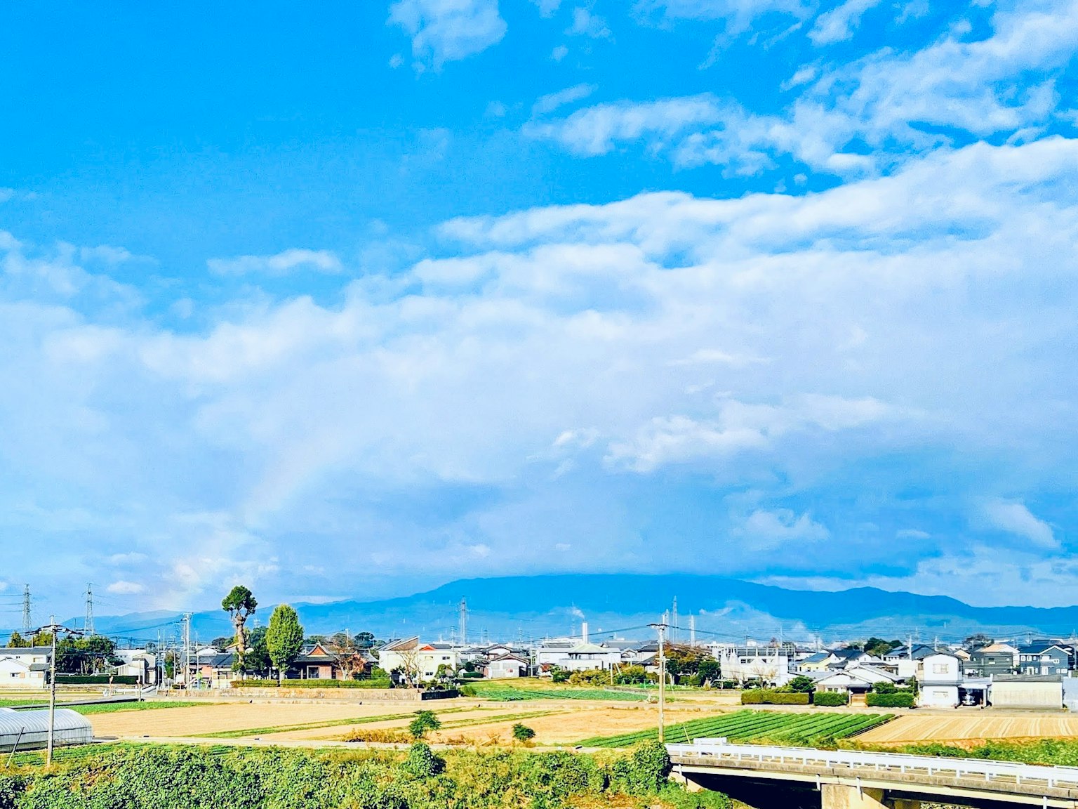 藍天和雲下的廣闊農村景觀與山脈