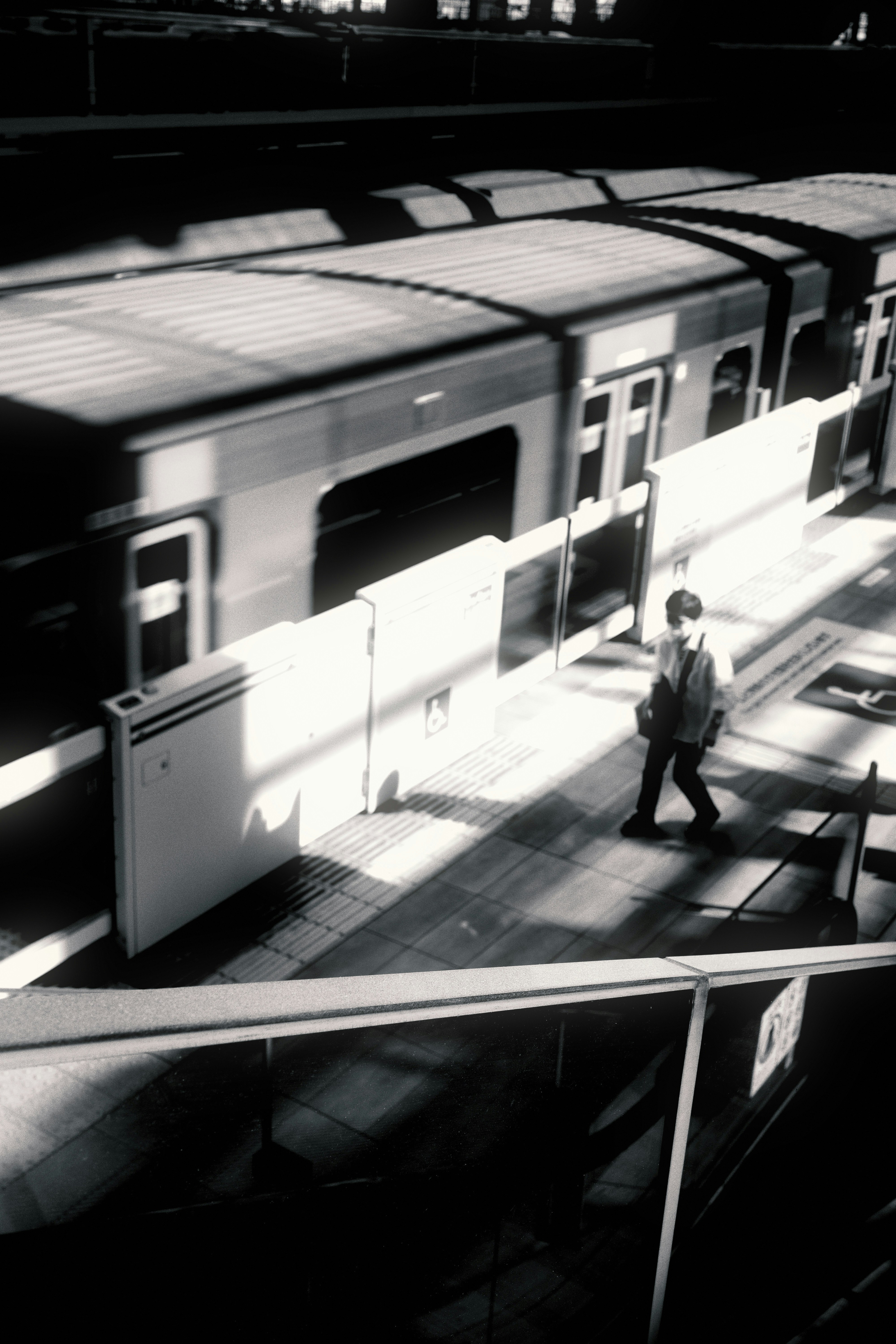 personne marchant sur un quai de gare en monochrome