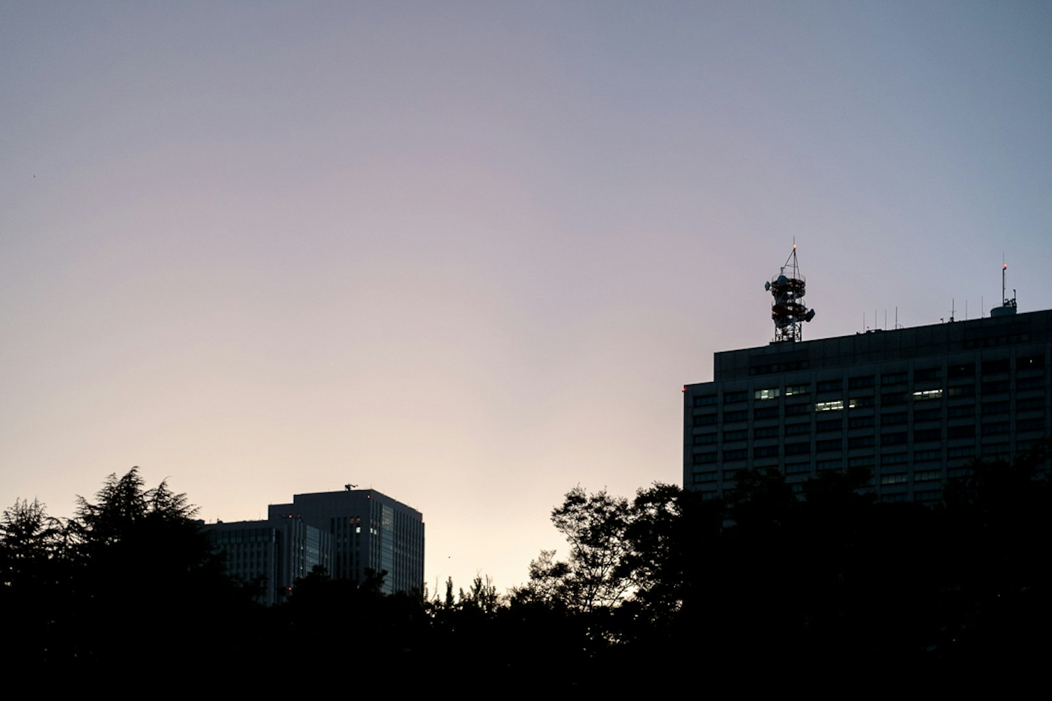 Horizon urbain au crépuscule avec des bâtiments en silhouette et des antennes