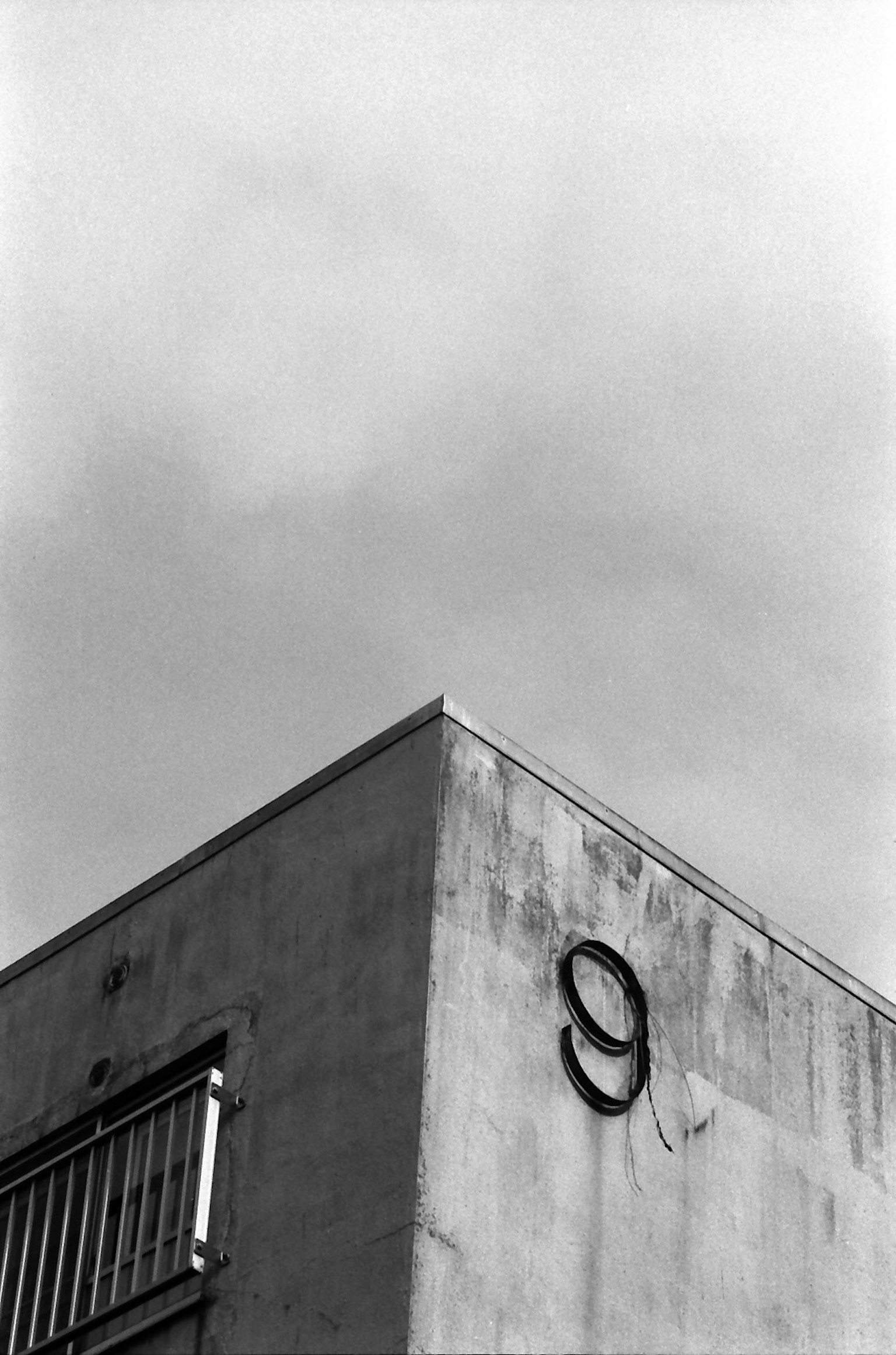 Schwarze Nummer 9 an einer Betonwand unter einem bewölkten Himmel