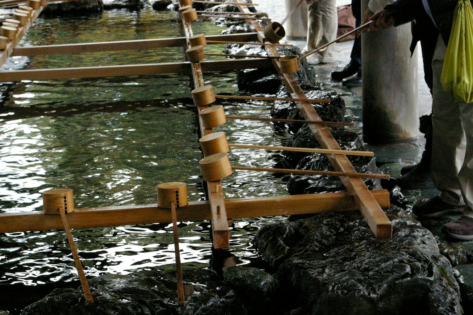 Struttura in legno sopra l'acqua con persone che lavorano nelle vicinanze