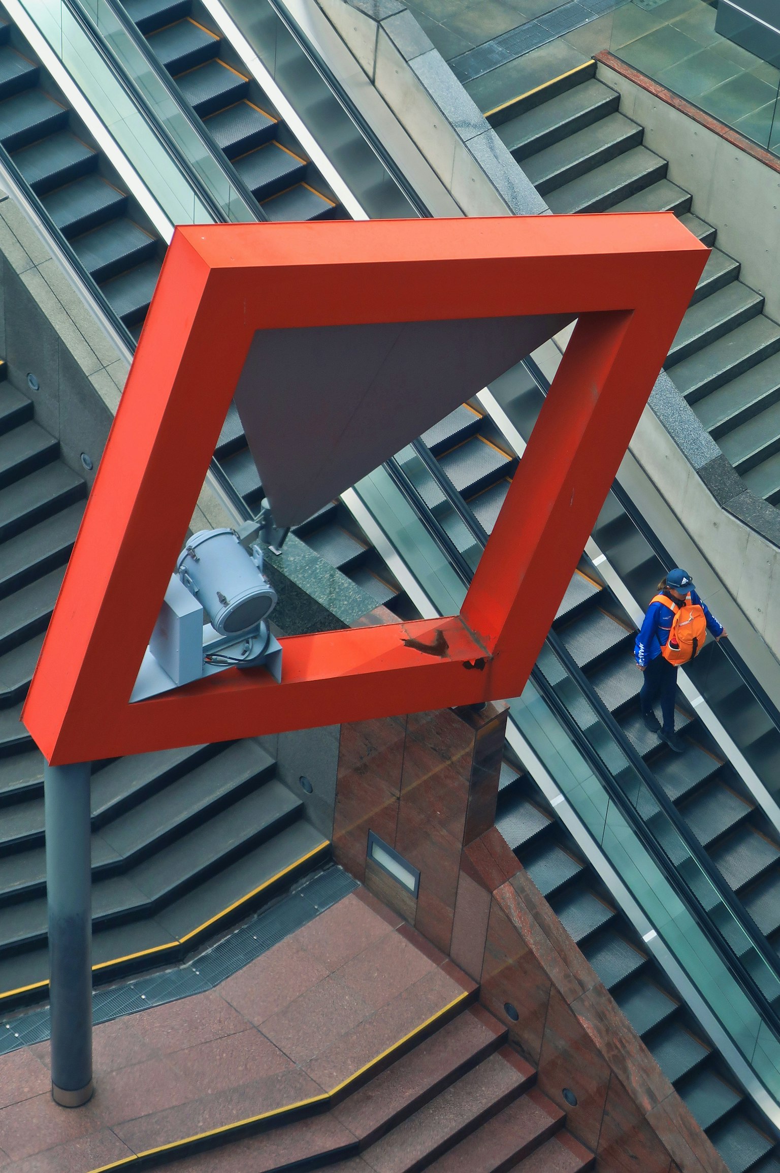階段に設置された大きな赤い三角形のオブジェとその周囲の構造