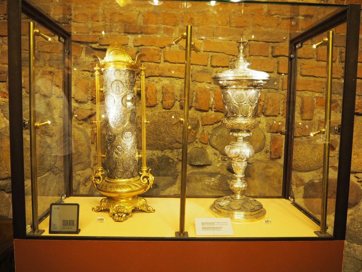 Oggetti decorativi in oro e argento esposti in una vetrina di vetro