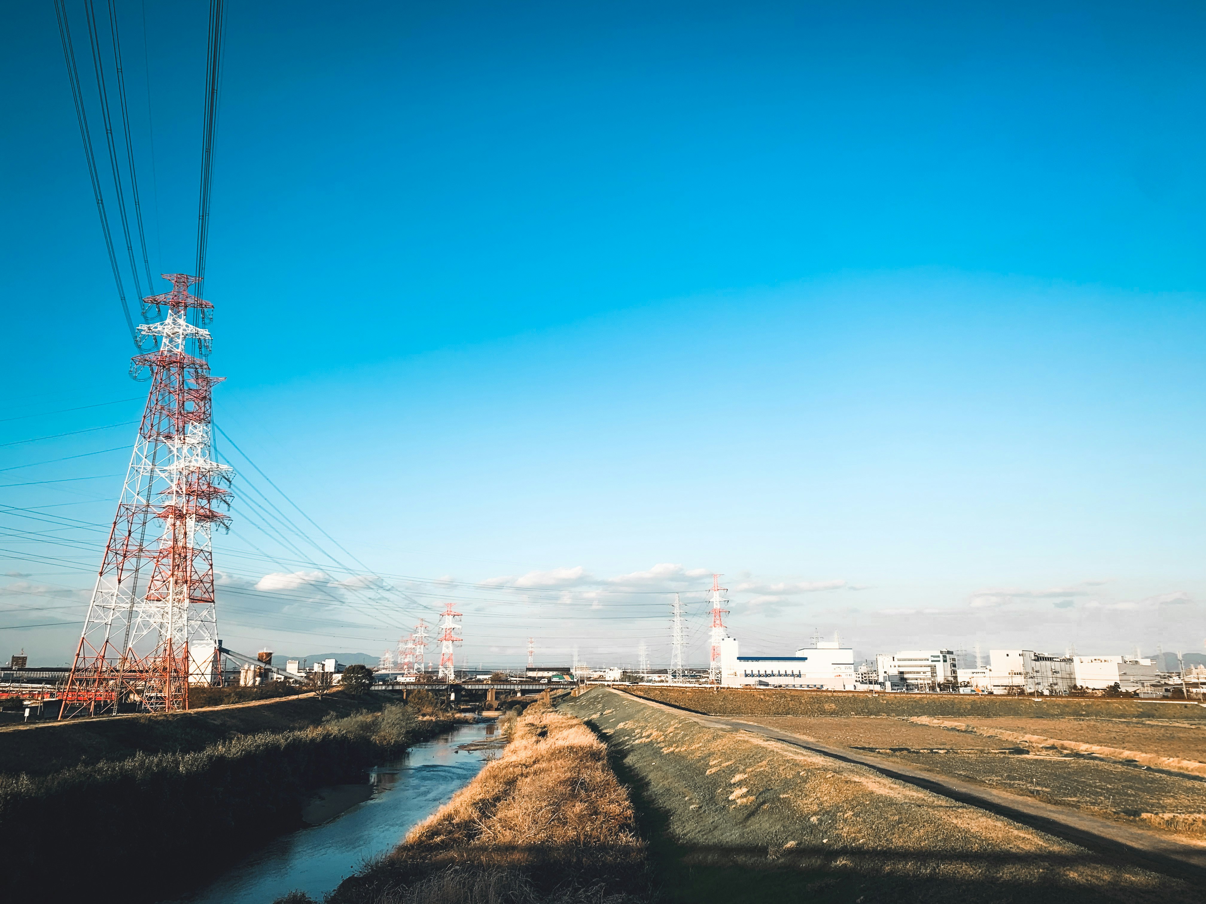 orilla de río con torres de transmisión eléctrica y zona industrial