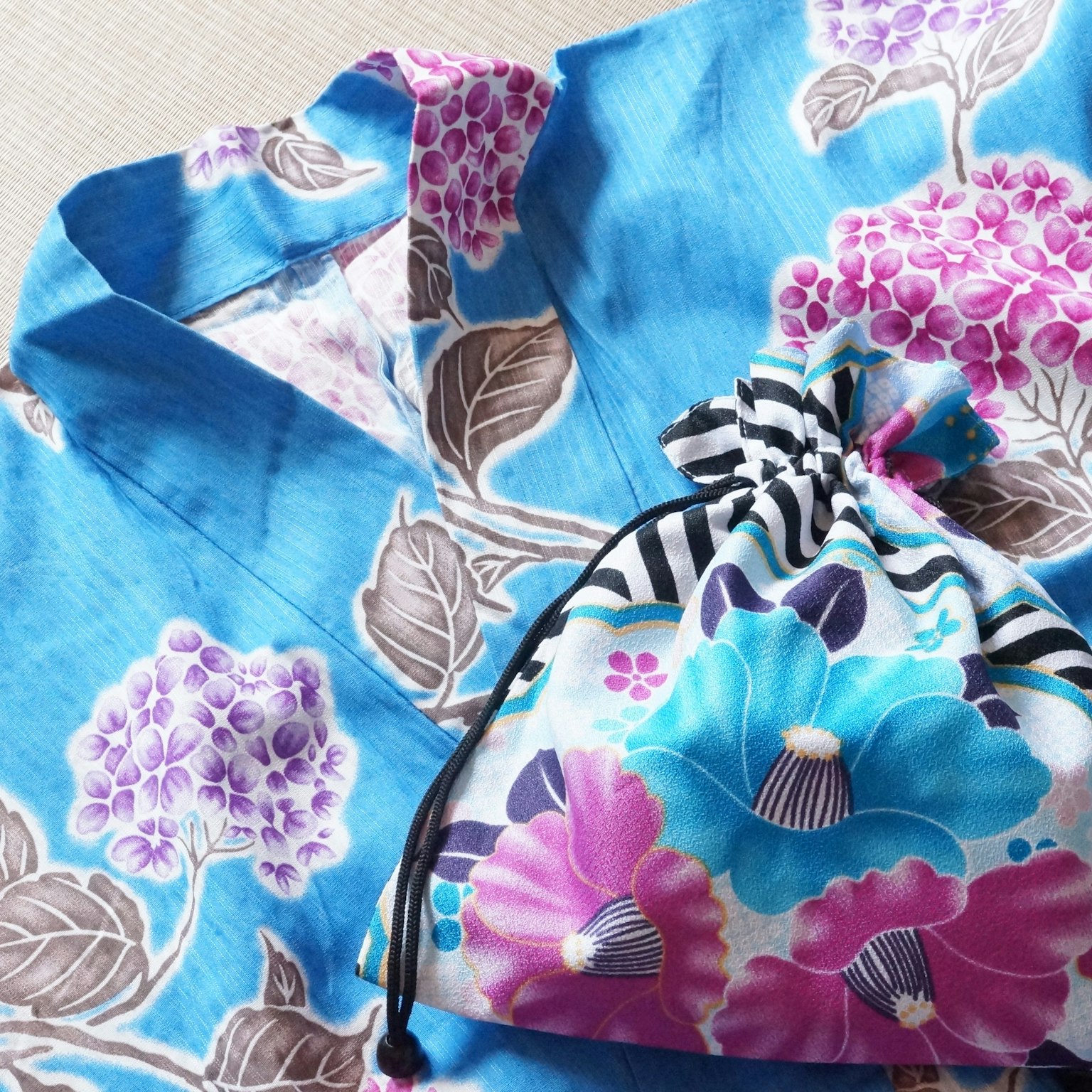 Kimono biru dengan pola bunga dan tas serut yang cocok