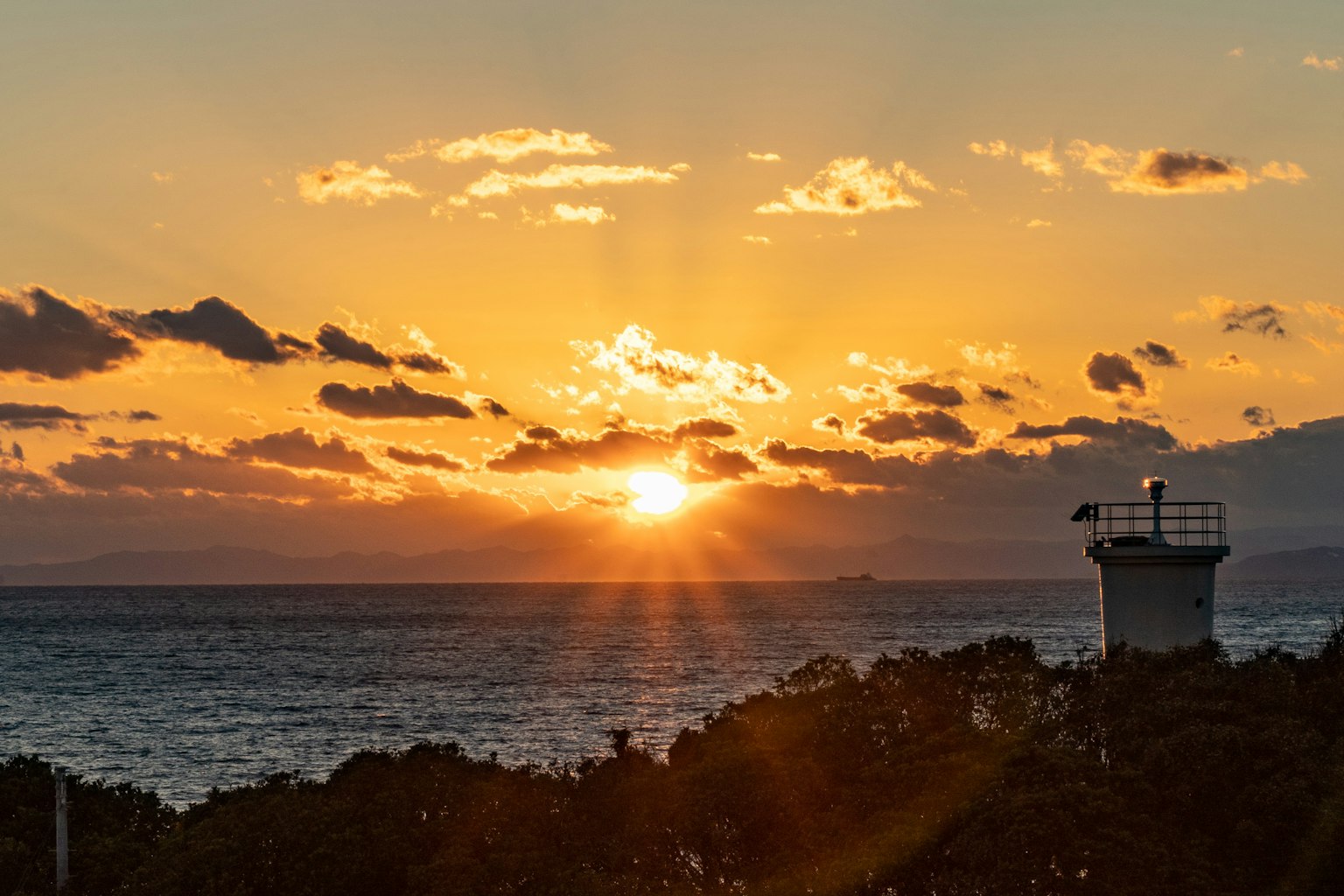 Beautiful sunset over the ocean with a lighthouse