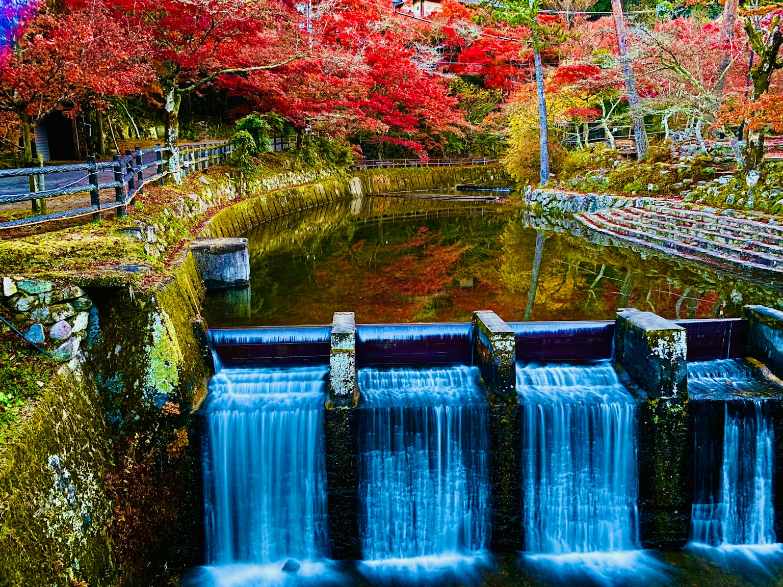 Beautiful stream reflecting colorful autumn leaves and calm water surface