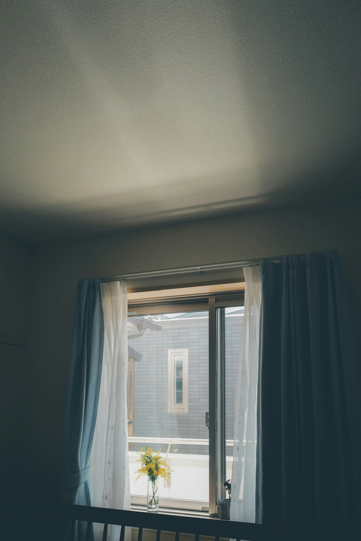 Foto interior de una habitación con una ventana brillante y cortinas