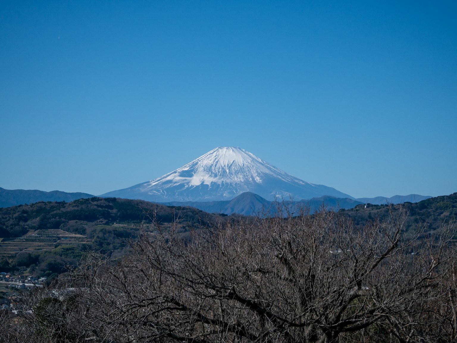 Beautiful view of Mount Fuji covered in snow with clear blue sky and surrounding mountains
