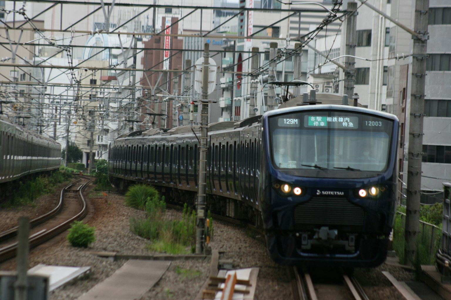 Un tren negro que circula por una vía urbana