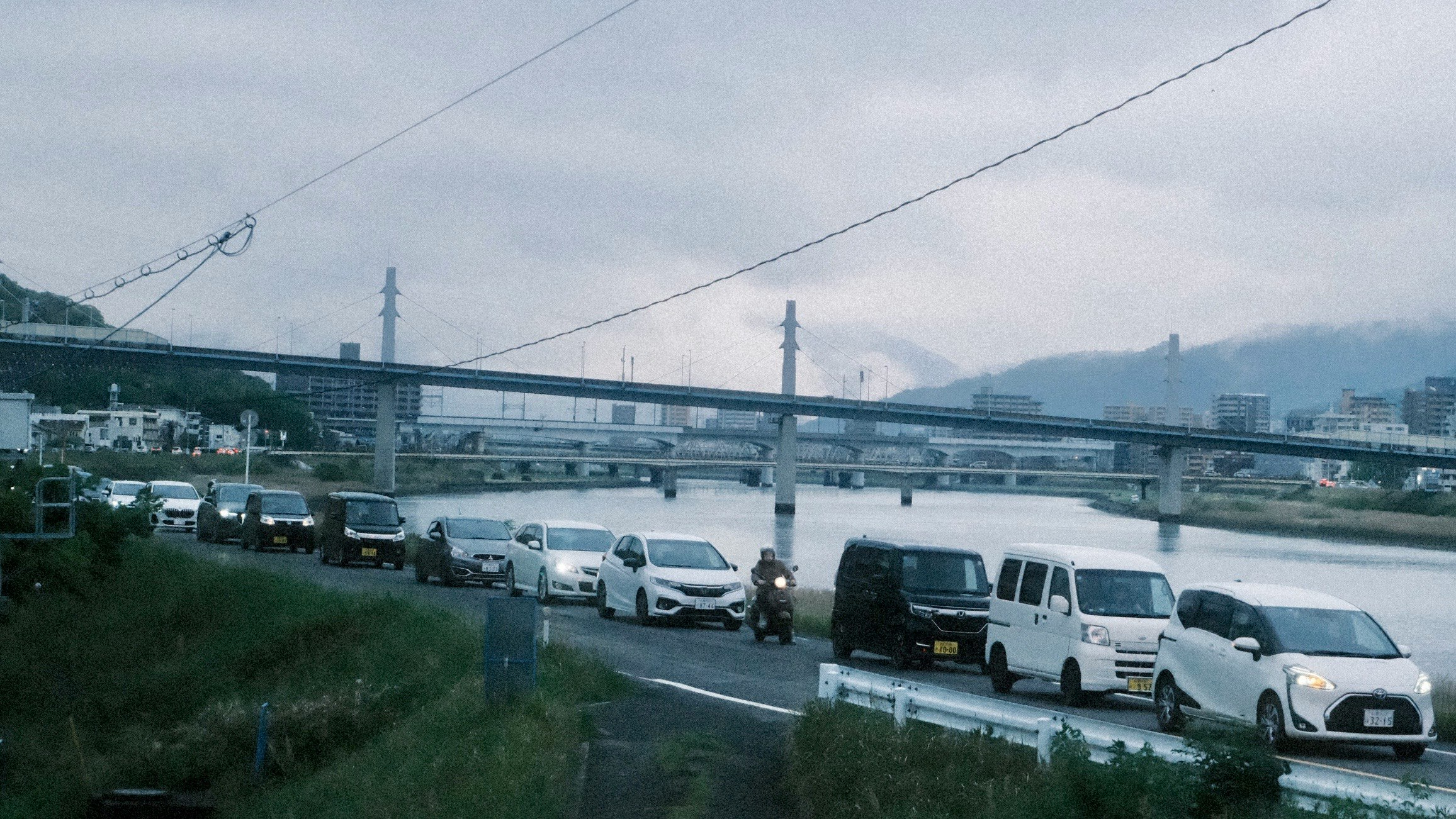 川沿いの高速道路を走る車とバスの流れ