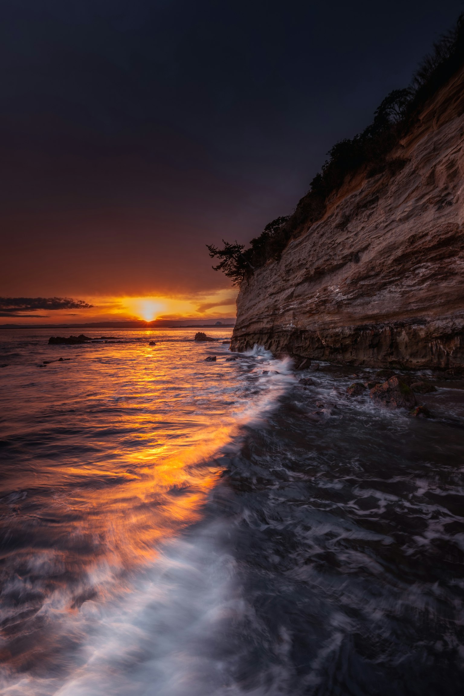 Magnifique paysage de coucher de soleil sur l'océan avec des falaises rocheuses et des vagues