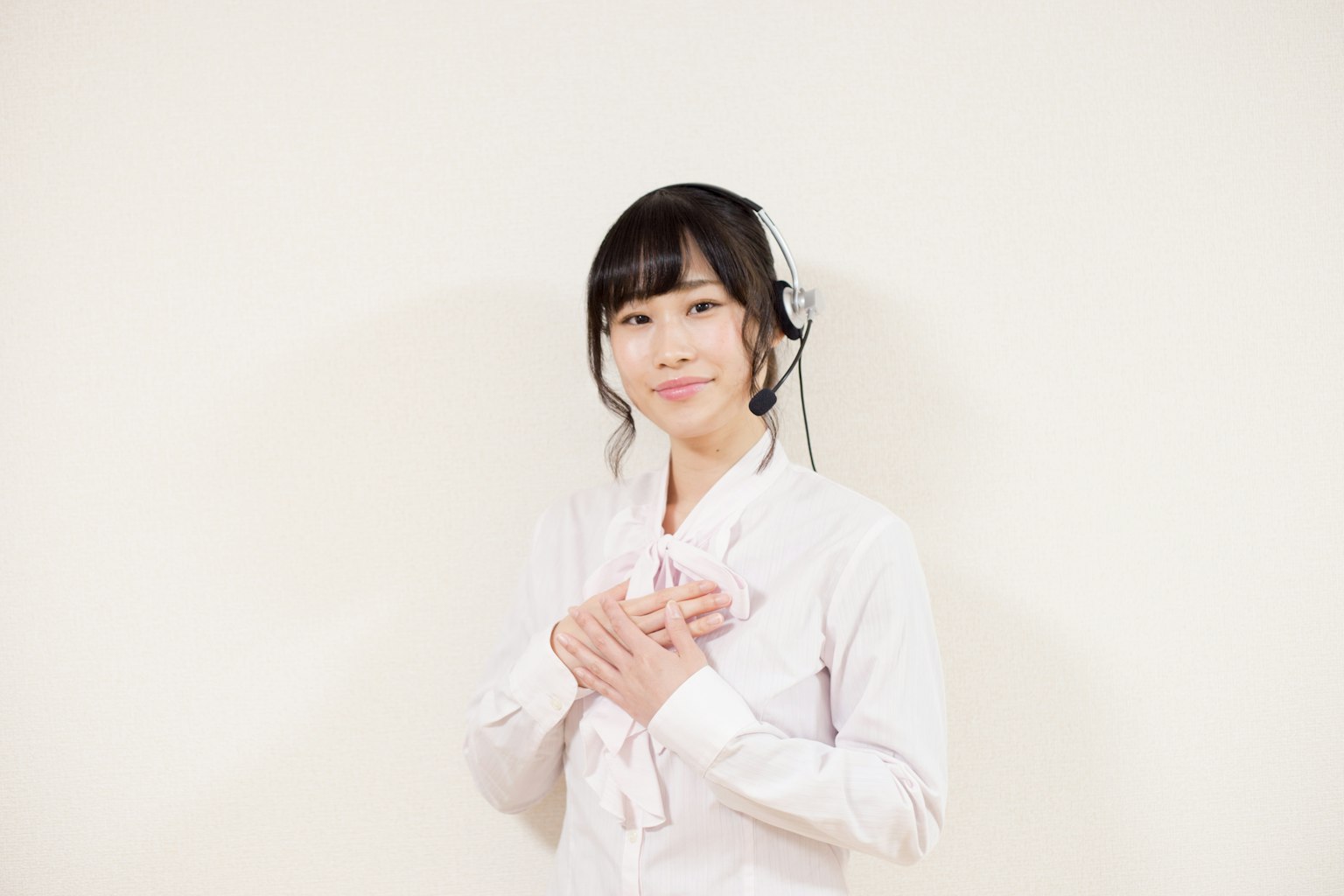 穿着白色制服的女性微笑着双手放在胸前
