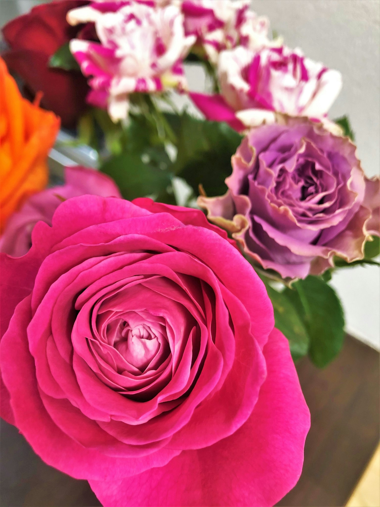 Un bouquet avec des roses roses et violettes éclatantes