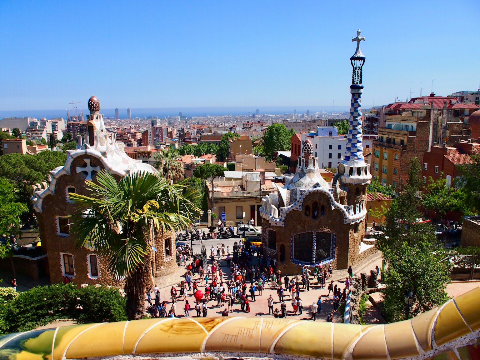 Vista del Parque Güell en Barcelona con personas reunidas alrededor de edificios únicos y vegetación