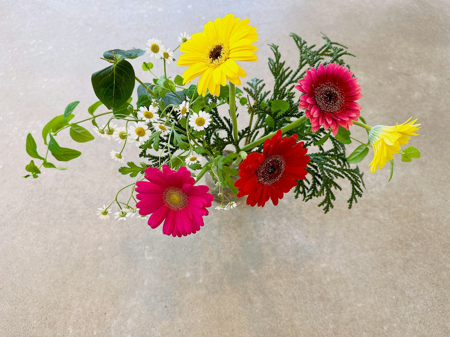 Ramo colorido con gerberas amarillas rosas y rojas y pequeñas flores blancas