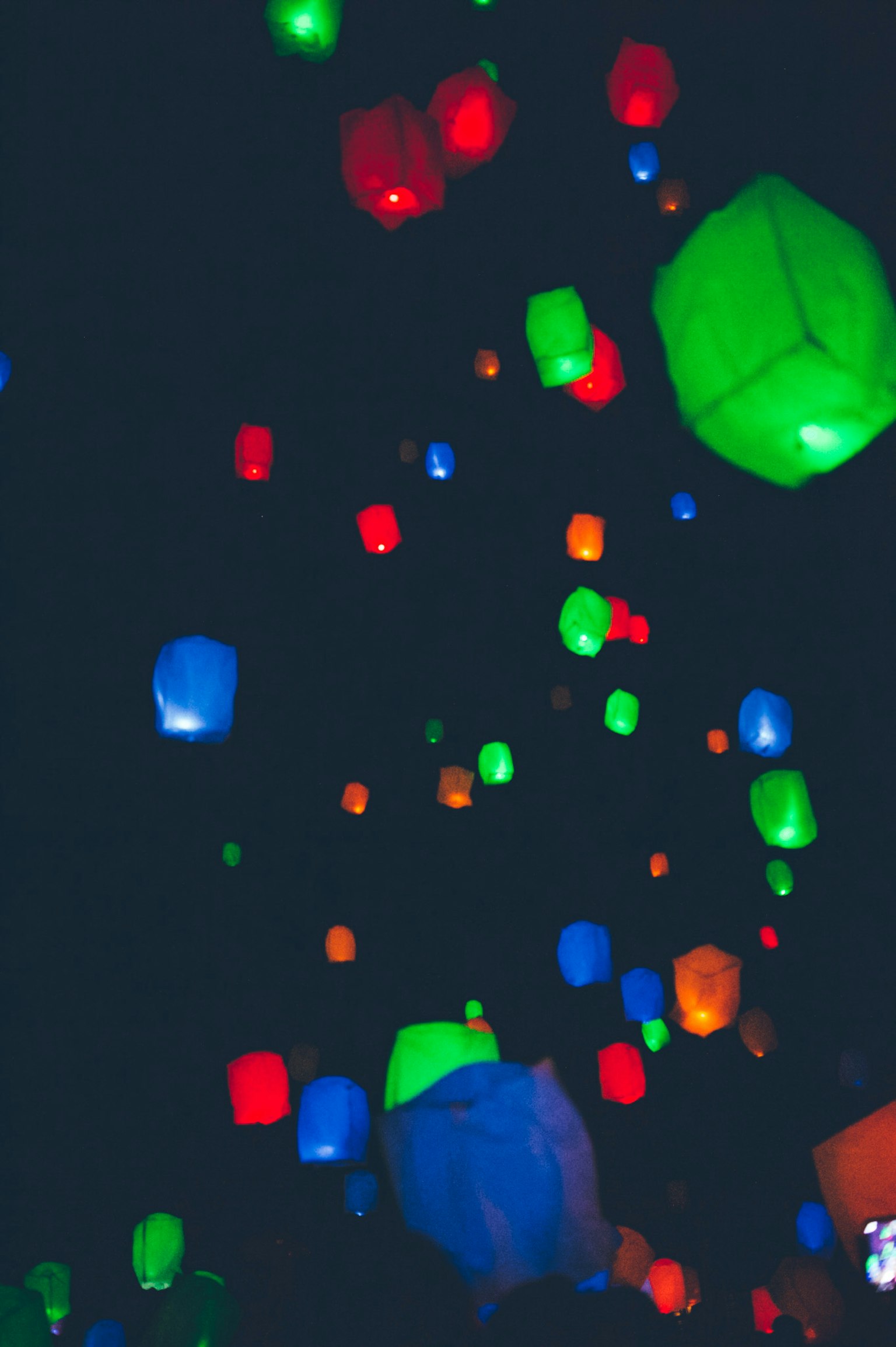 Colorful lanterns floating in the night sky creating a magical atmosphere