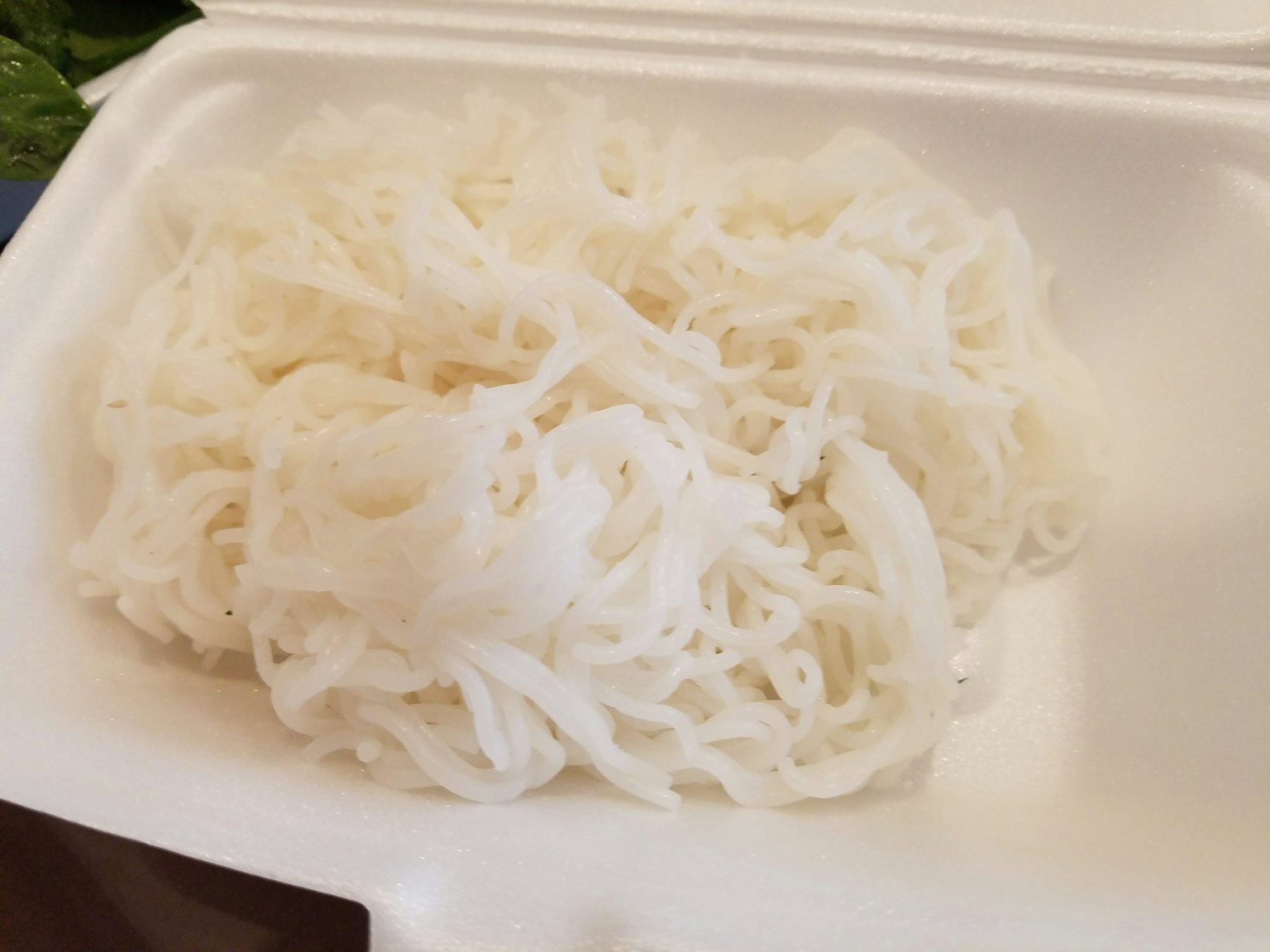 흰 쌀국수가 용기에 쌓여 있다