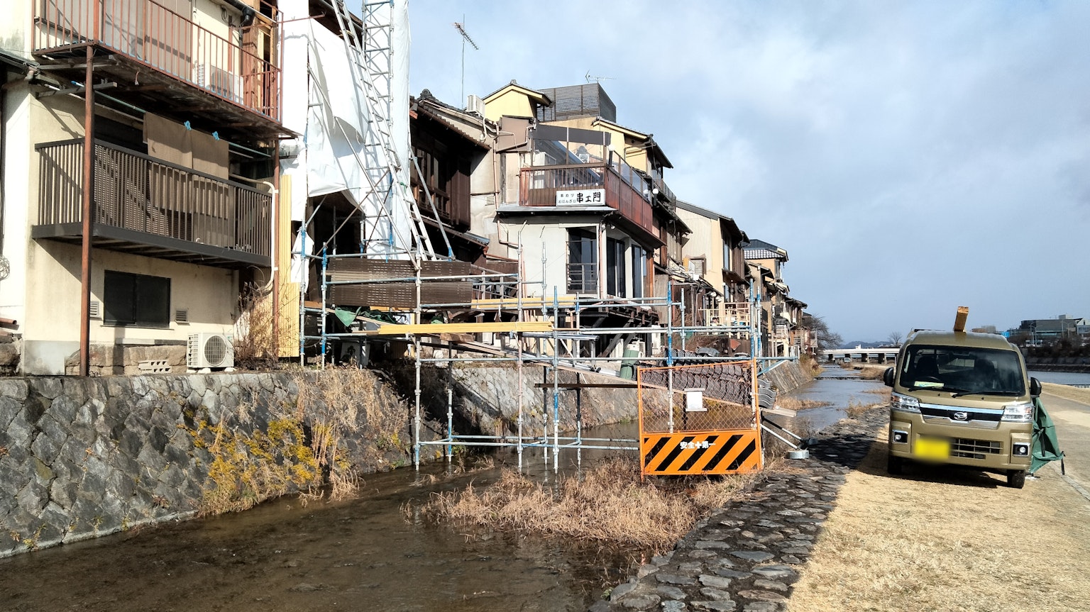 Paesaggio con edifici lungo il fiume e recinzioni di costruzione