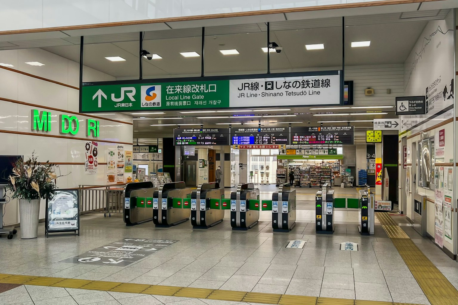 Pemandangan gerbang tiket dan papan informasi stasiun