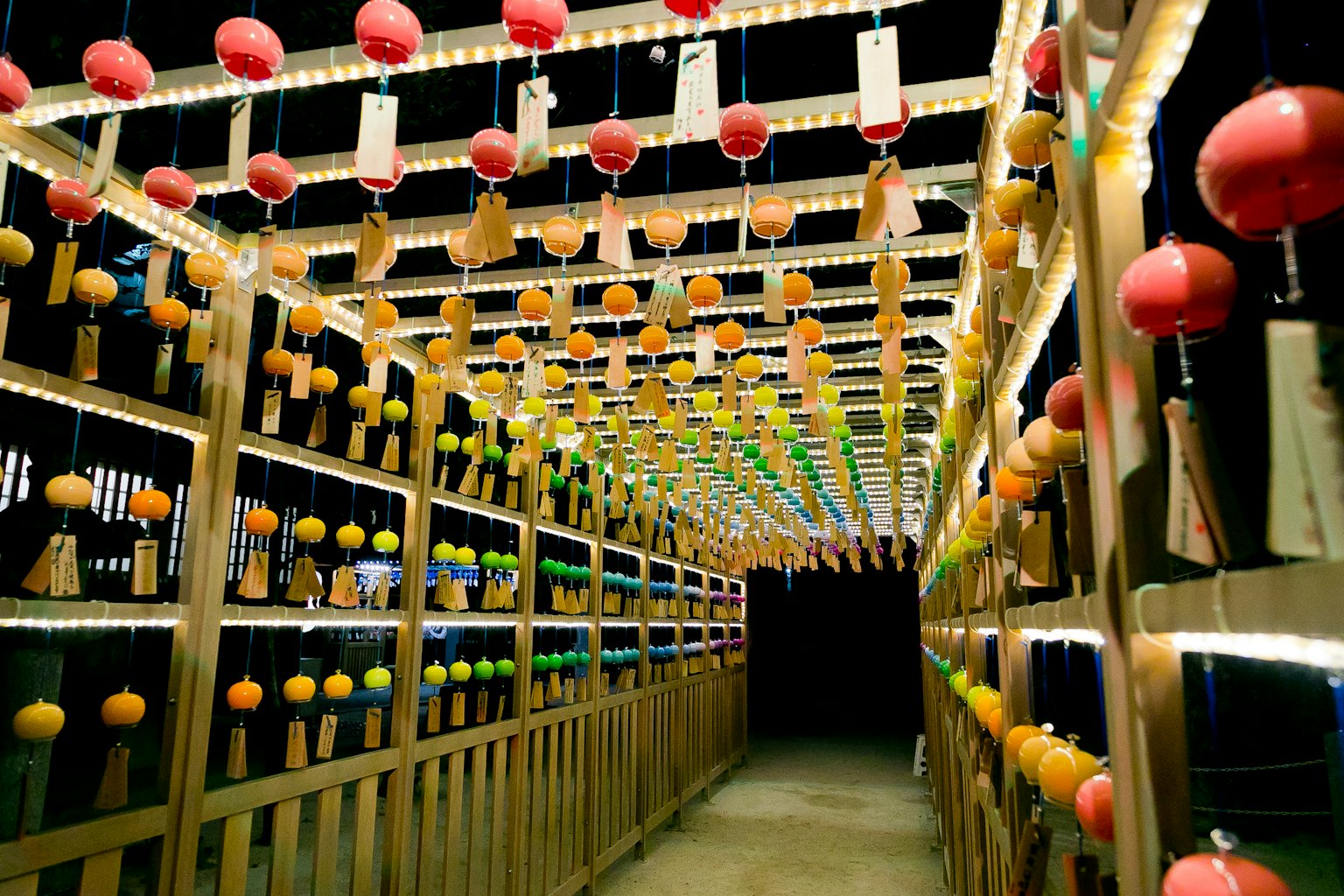 Bunte Windspiele hängen in einem traditionellen japanischen Windspielkorridor