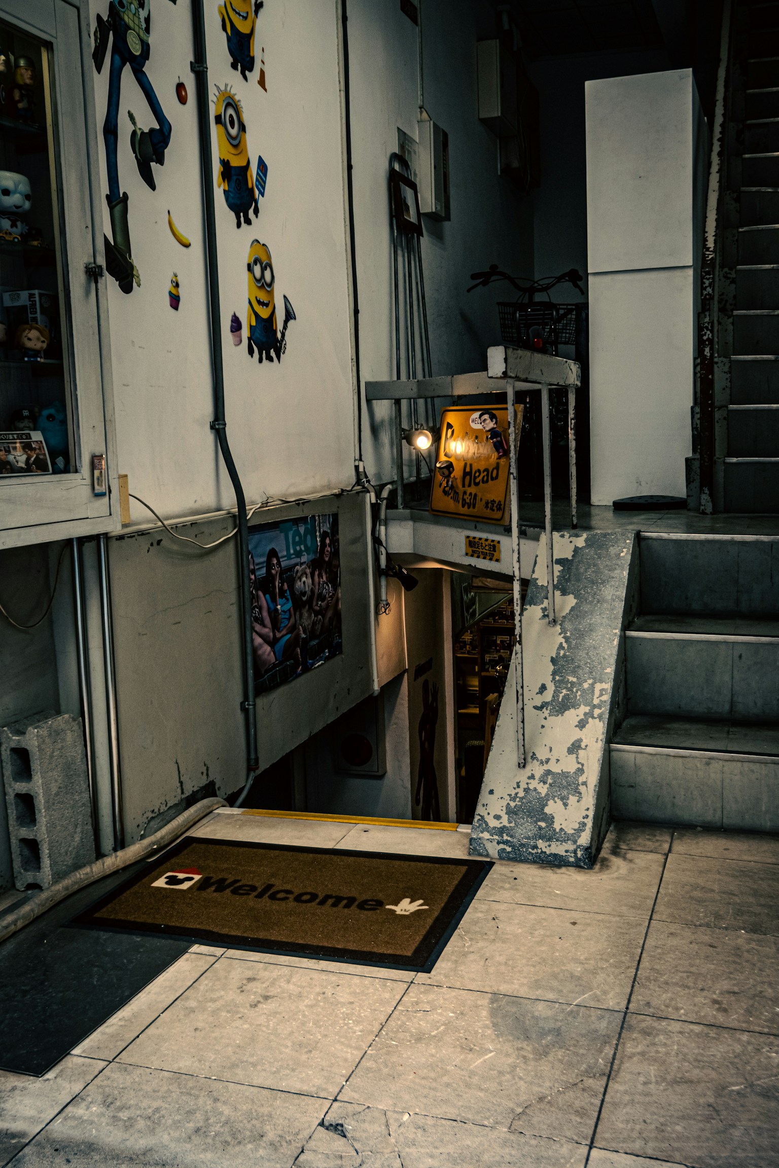Eingang mit Treppe nach unten und Minion-Wandkunst in einem schwach beleuchteten Flur