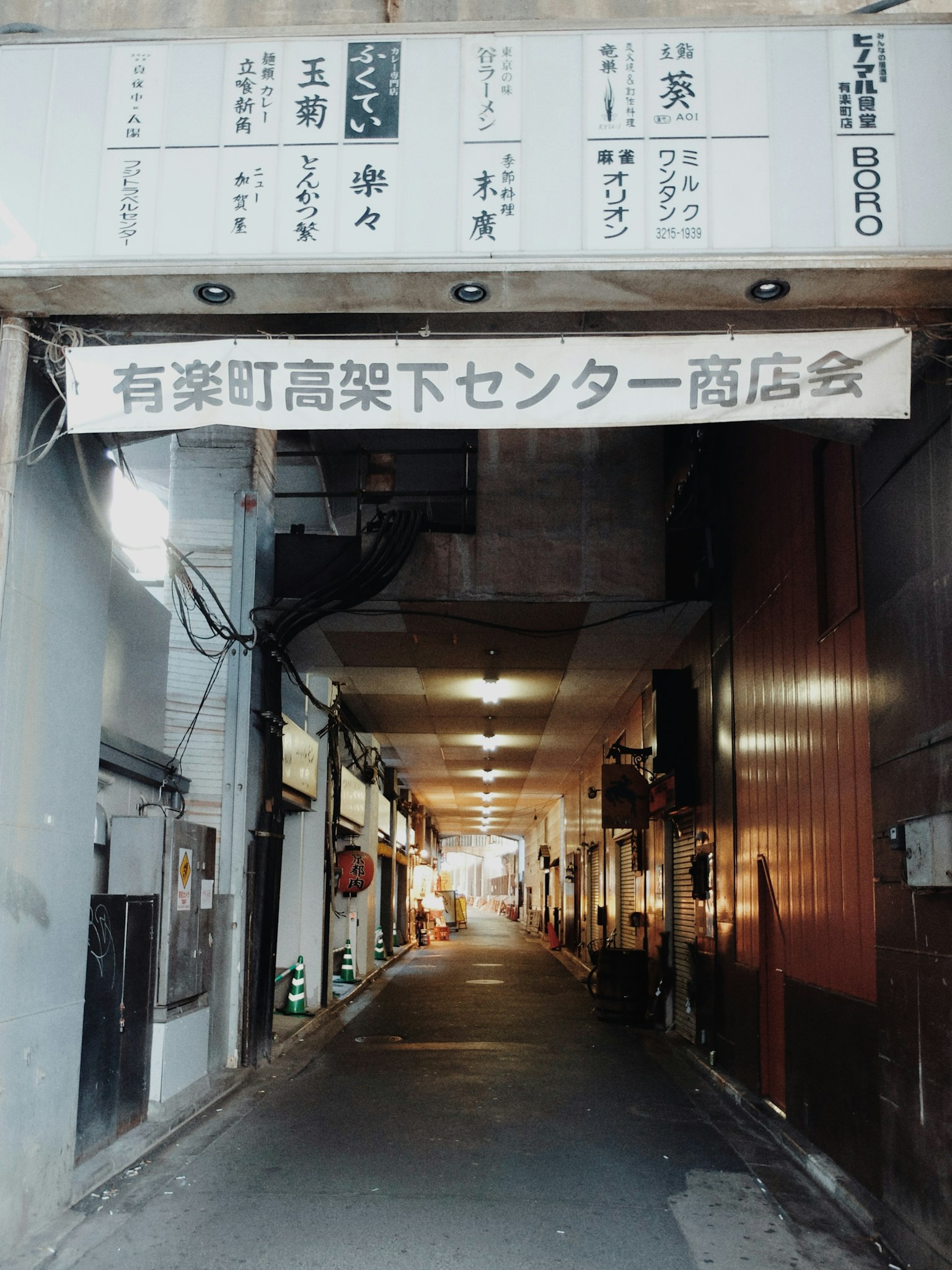 Foto einer Einkaufsstraße in Yurakucho mit Geschäften auf beiden Seiten und heller Beleuchtung