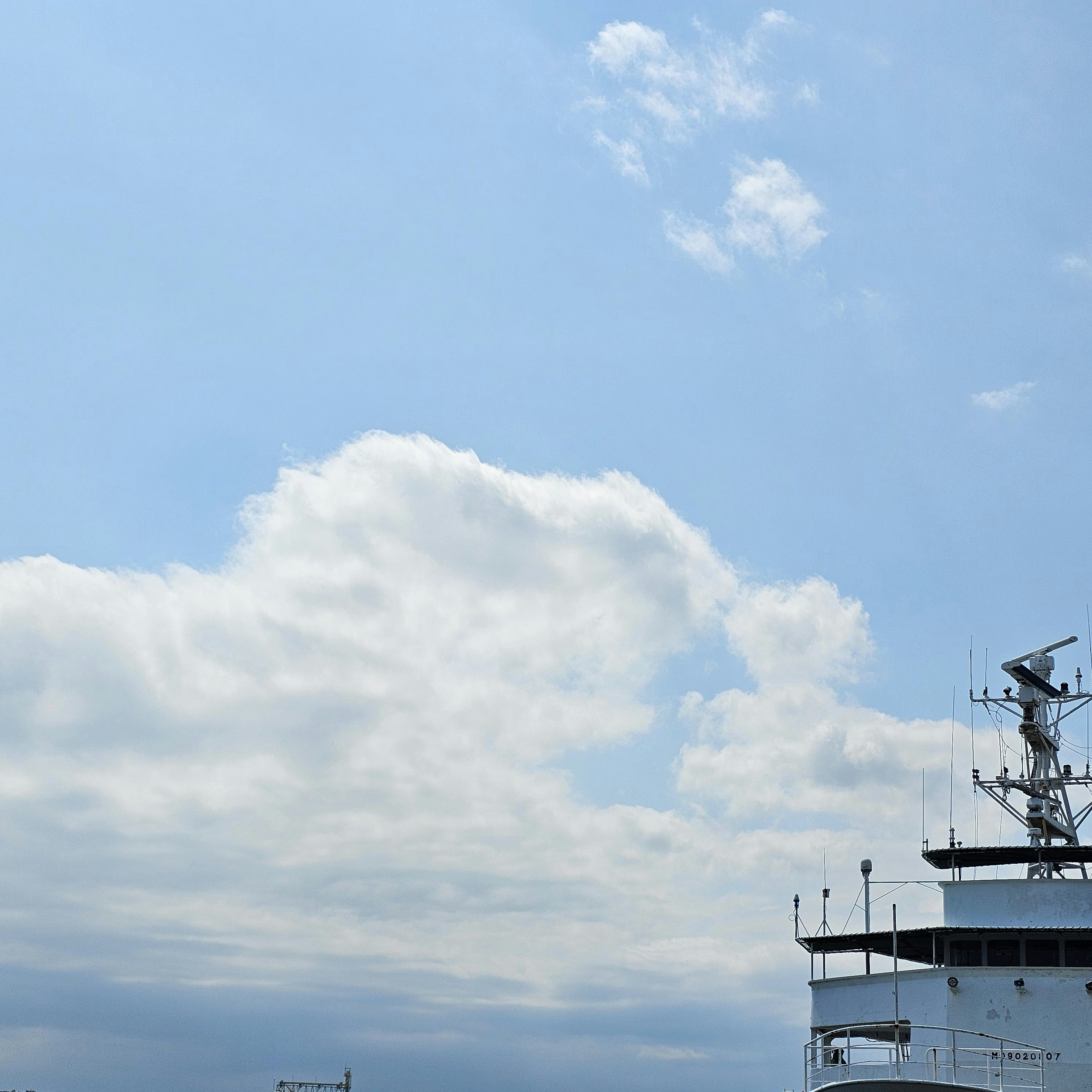 空に浮かぶ雲と船の船首上部