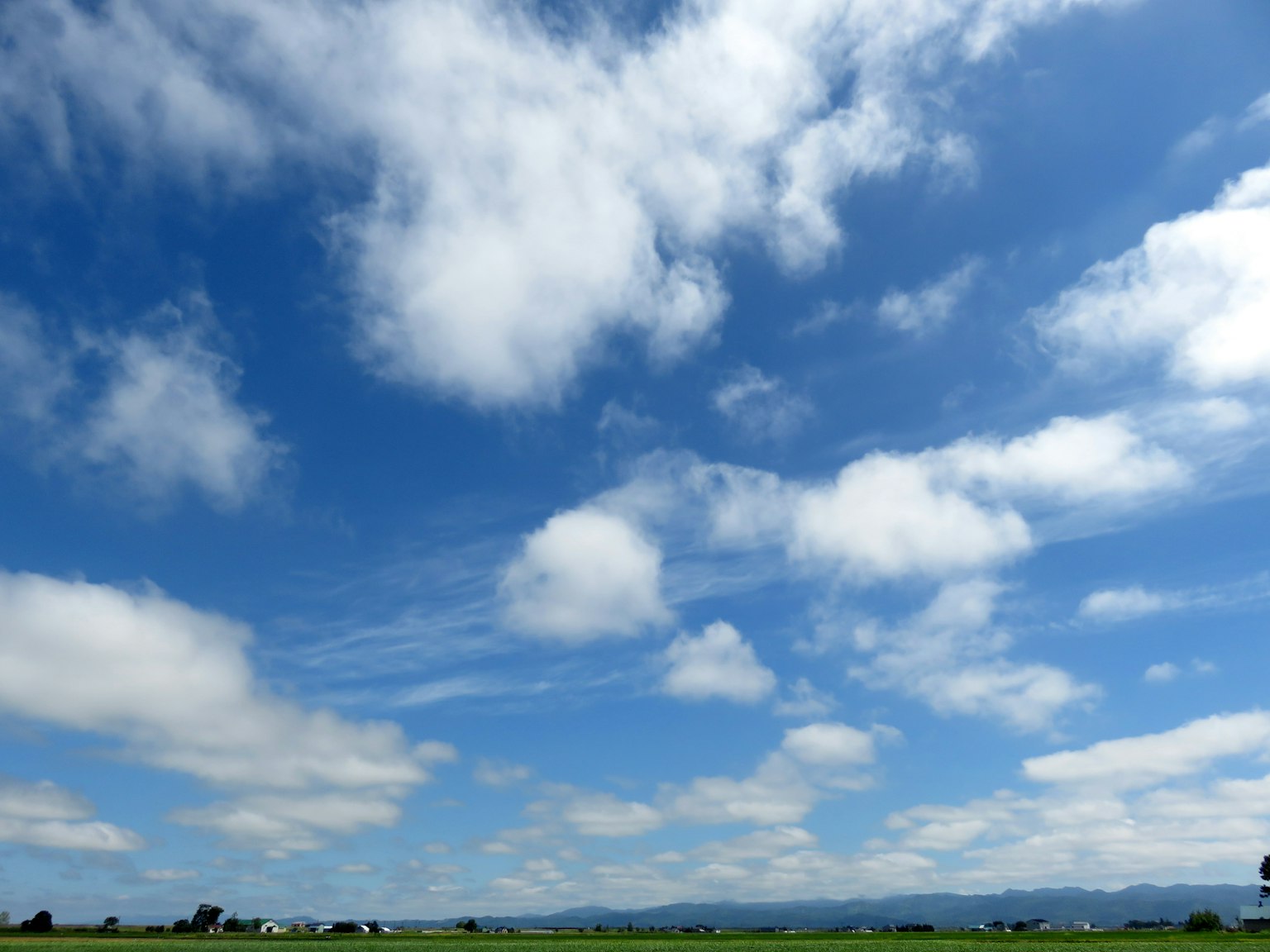 Eine Landschaft mit blauem Himmel und weißen Wolken