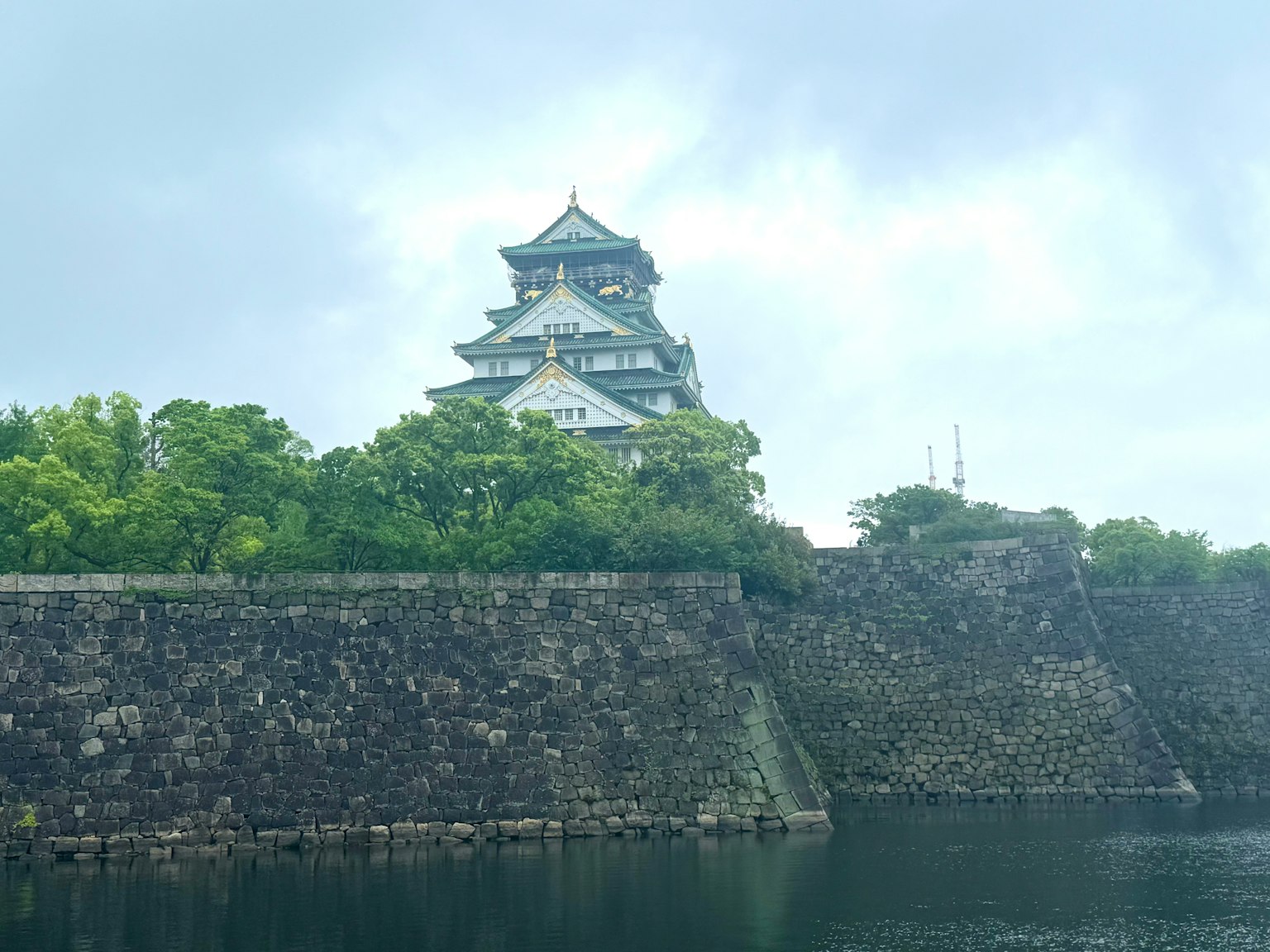 Osaka Castle surrounded by greenery and stone walls