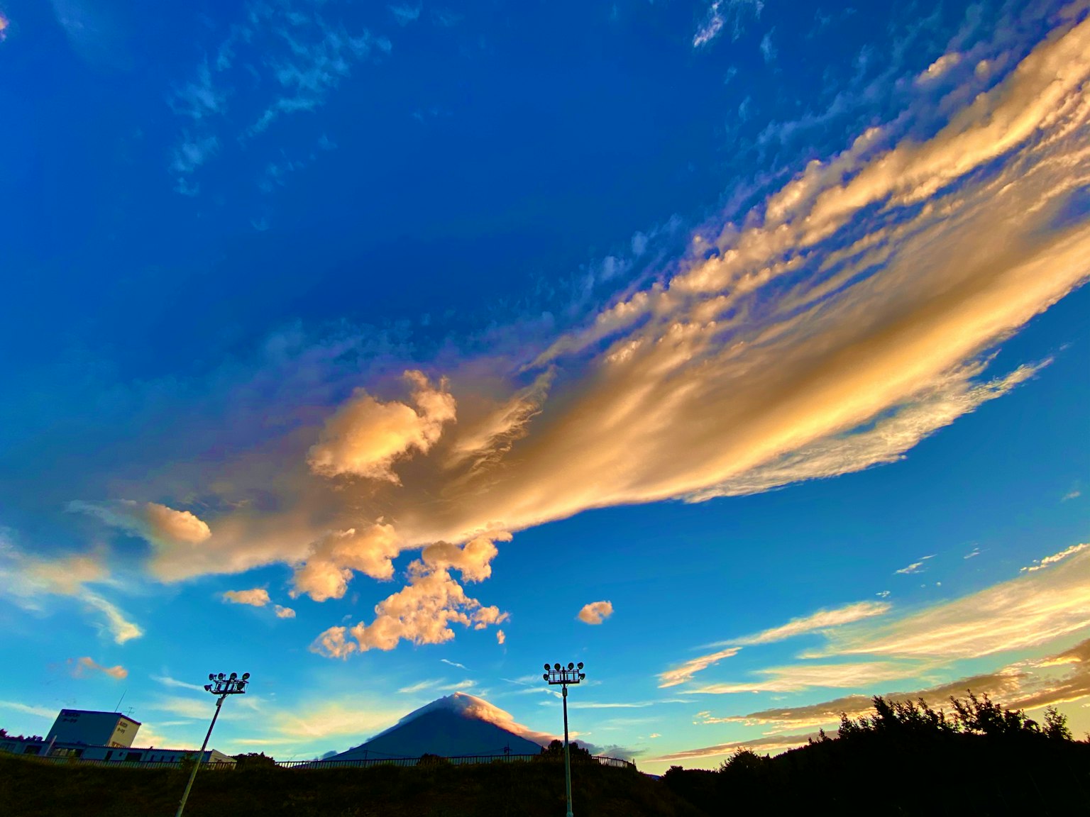 Cielo al tramonto pittoresco con nuvole e silhouette di montagna