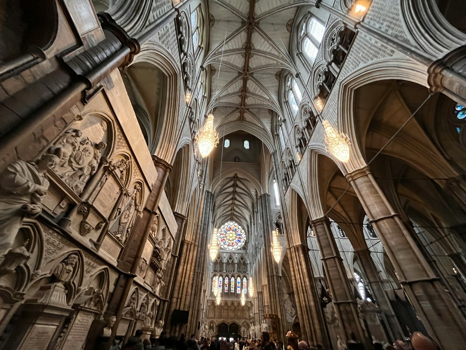 Innenraum einer großen Kathedrale mit hohen Decken und schönen Buntglasfenstern, beleuchtet von Kronleuchtern