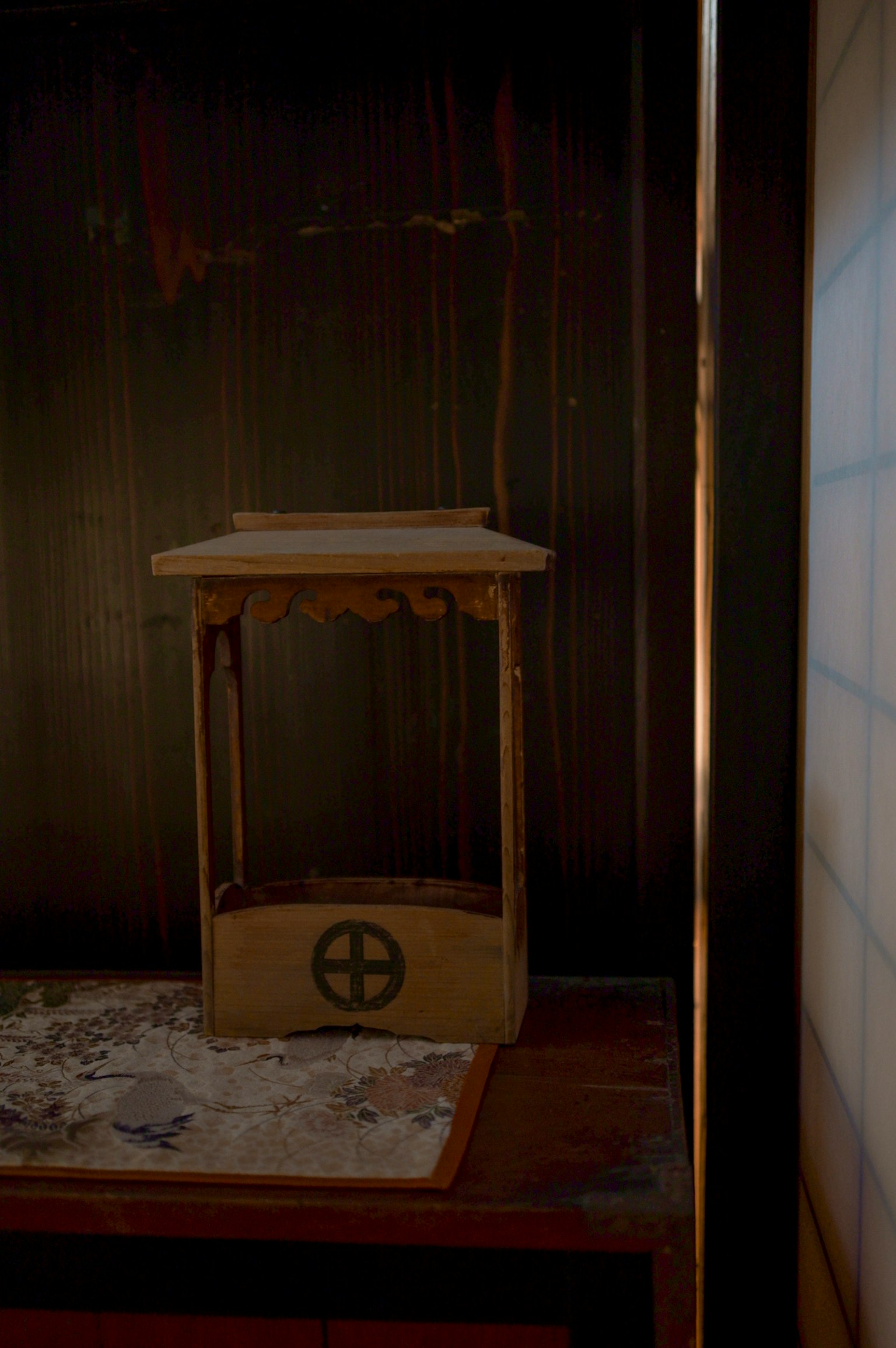 Wooden stand with a circular symbol on a dark background and white powder underneath