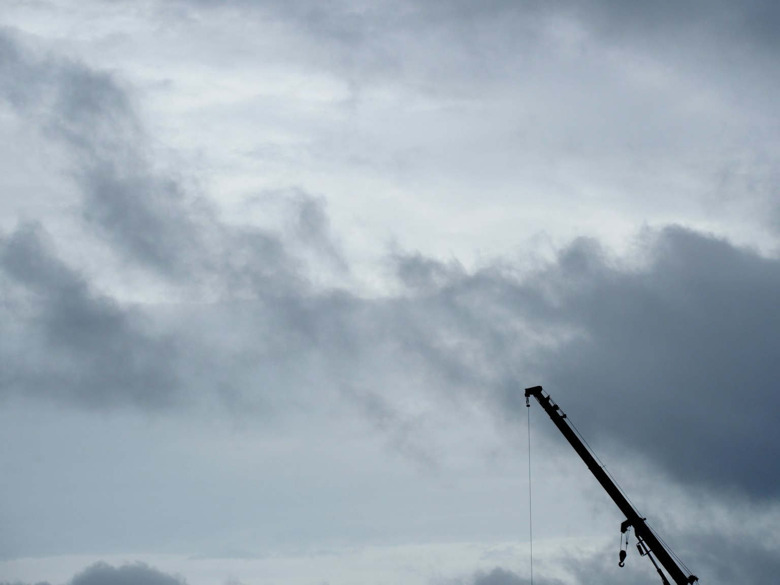Photo d'un ciel gris avec des nuages et la silhouette d'une grue