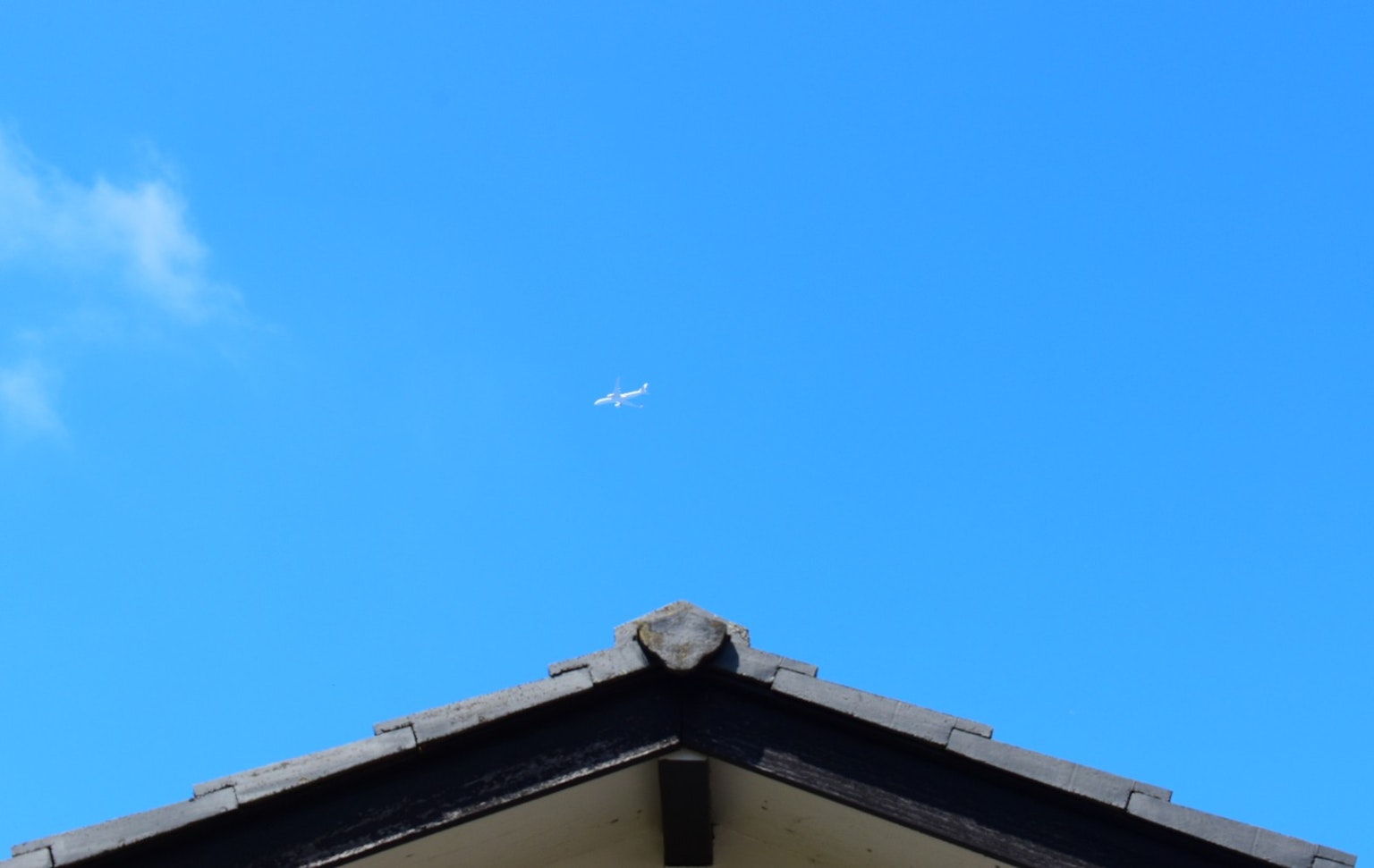 Pesawat kecil di langit biru di atas atap