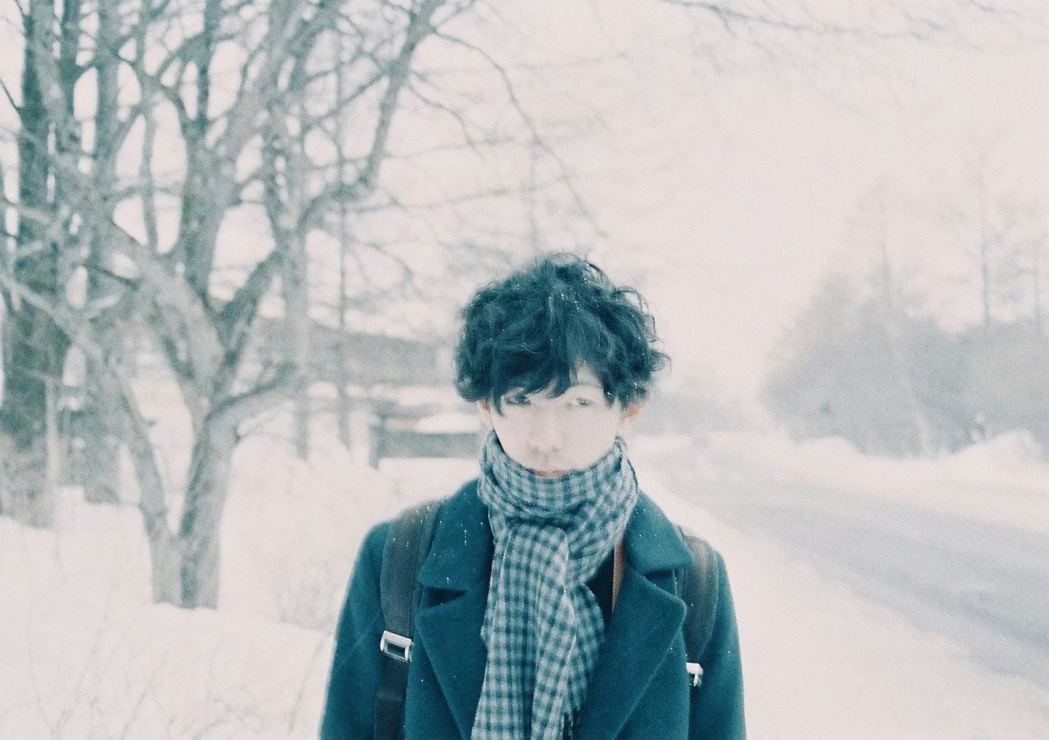 雪道を歩くマフラー姿の人物