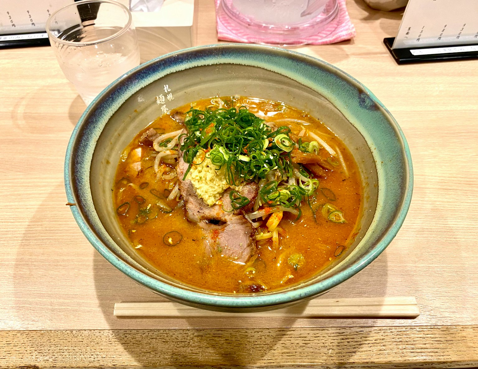 맛있는 라멘 그릇에 국물과 다양한 토핑이 담겨 있다