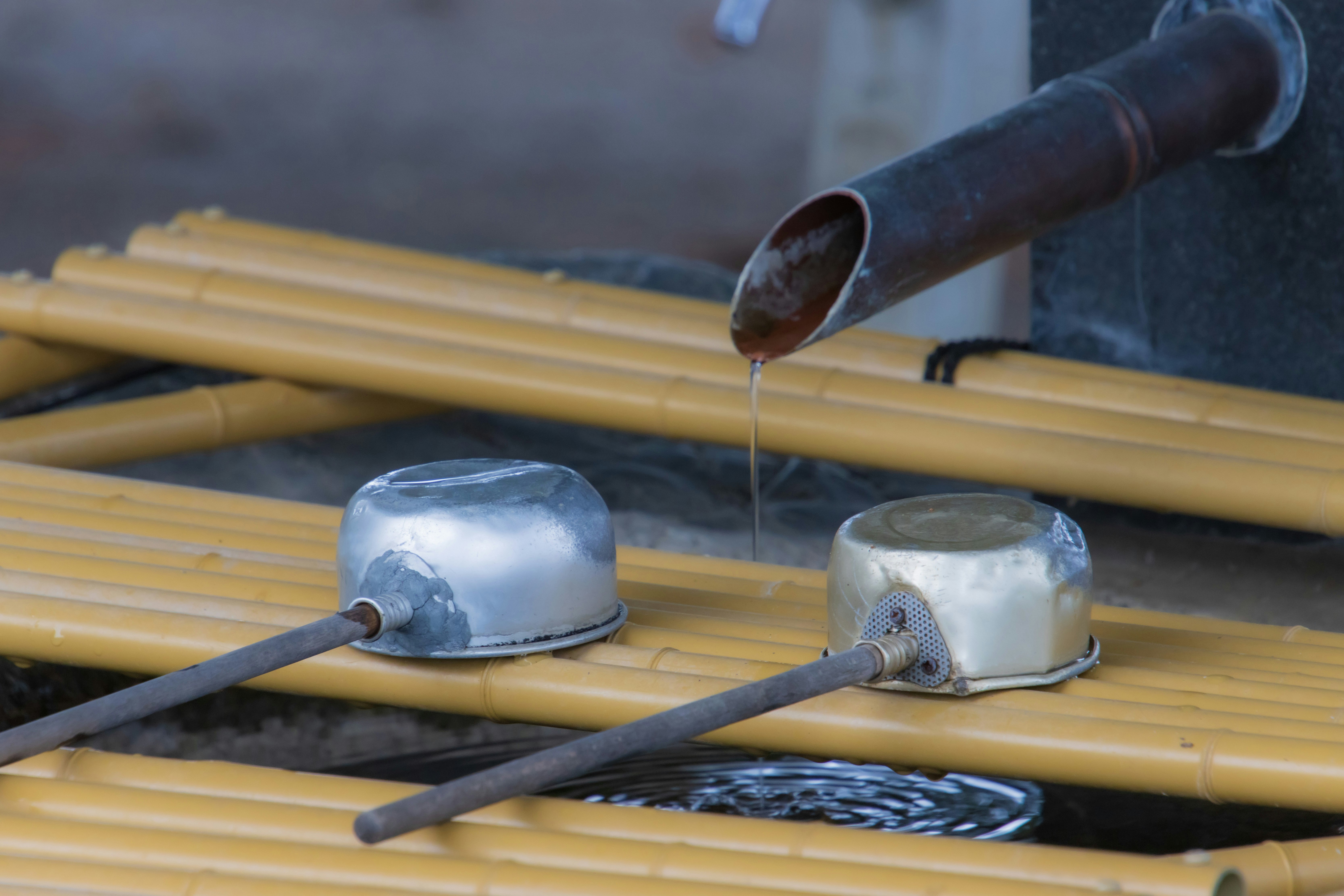 ladle placed in a water basin with bamboo