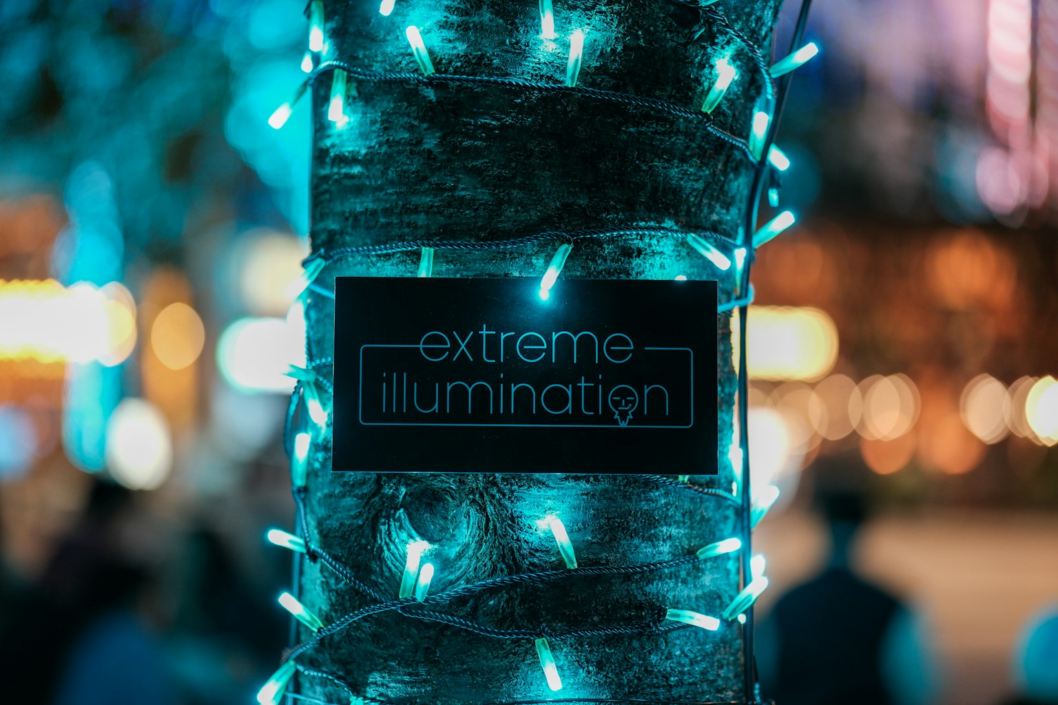 Tronco de árbol adornado con luces azules con un letrero de iluminación extrema
