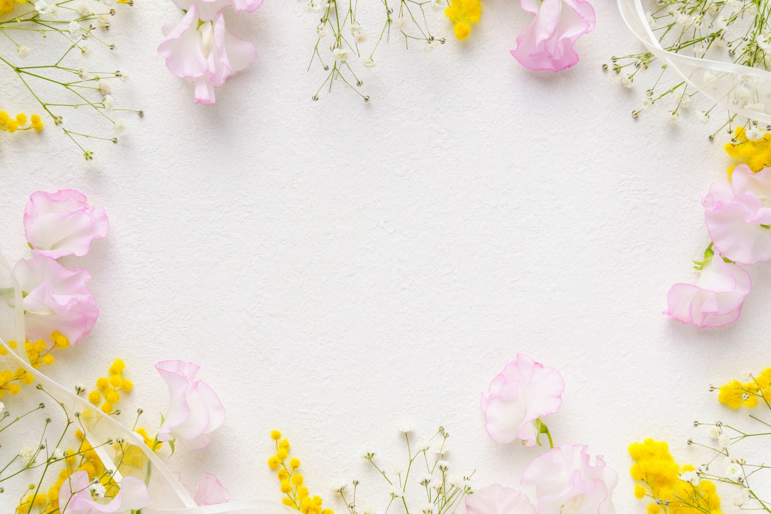 Zarte rosa und gelbe Blumen um einen weißen Hintergrund