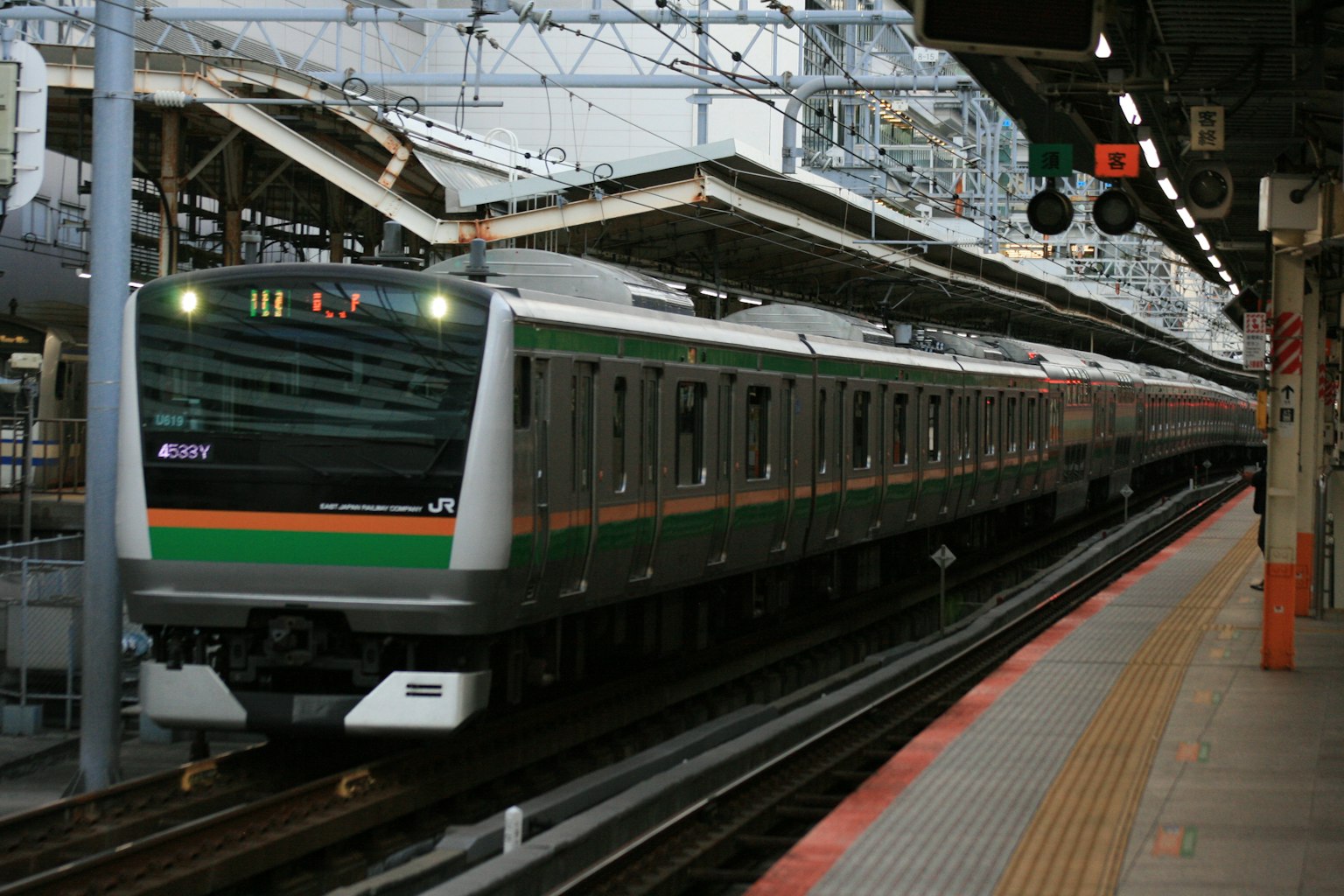 Treno con design verde e bianco in arrivo alla stazione