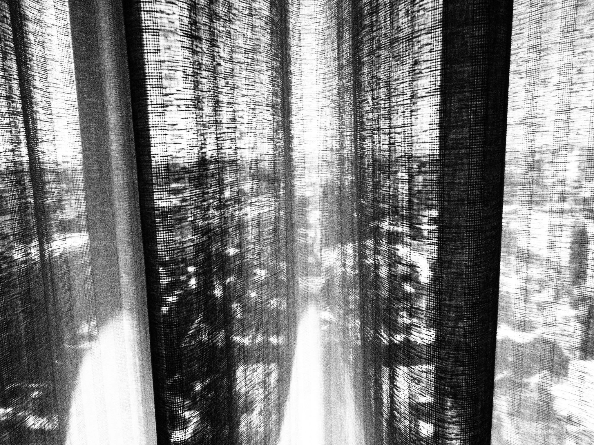 monochrome Fensterszene mit Licht und Schatten durch Vorhänge